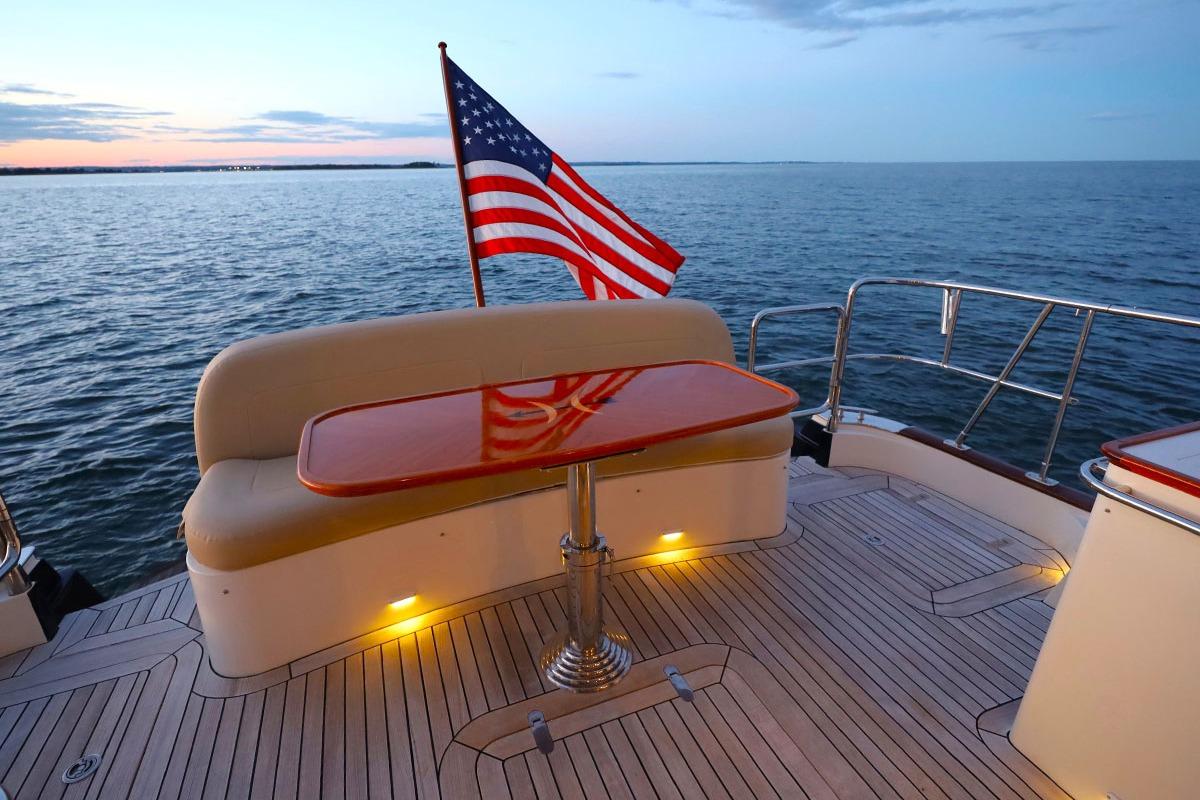 Luxurious 2014 Hunt Yachts 44 with American flag, sunset view, and elegant deck seating.
