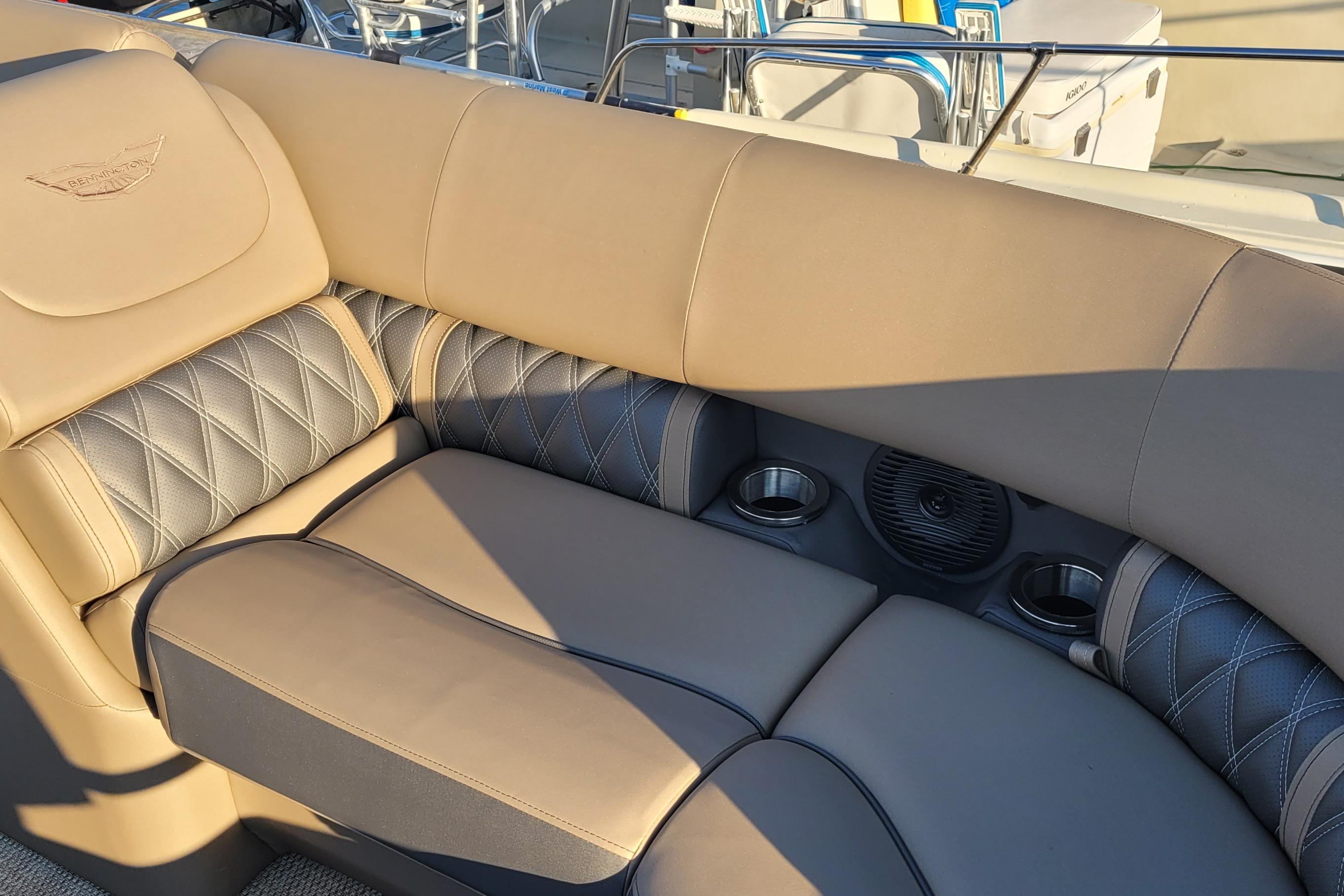Luxurious seating on 2024 Bennington 24LXSSB boat with cup holders and speaker.