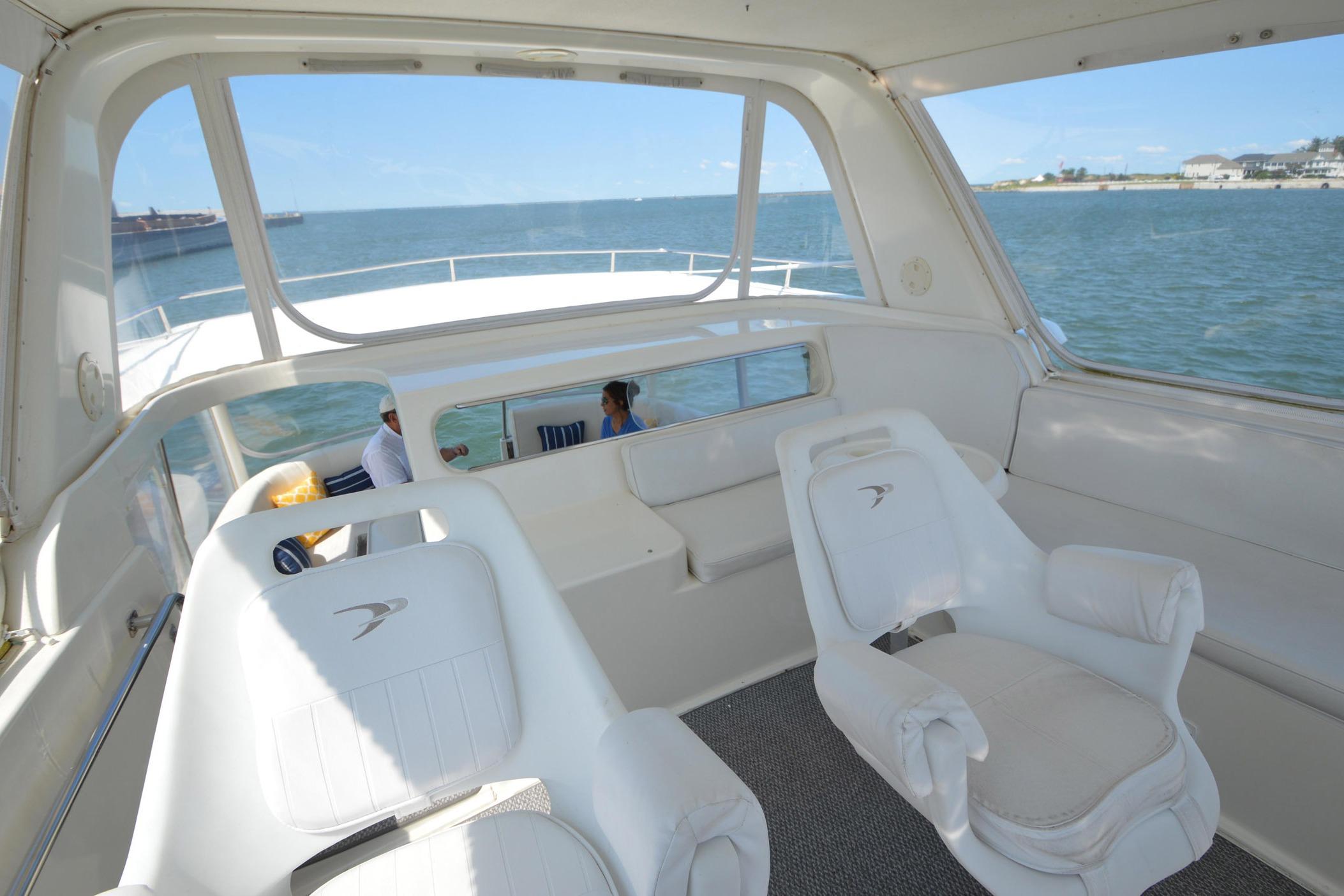 Interior view of 1995 Ocean 48 Cockpit Motor Yacht with white seating and ocean backdrop.