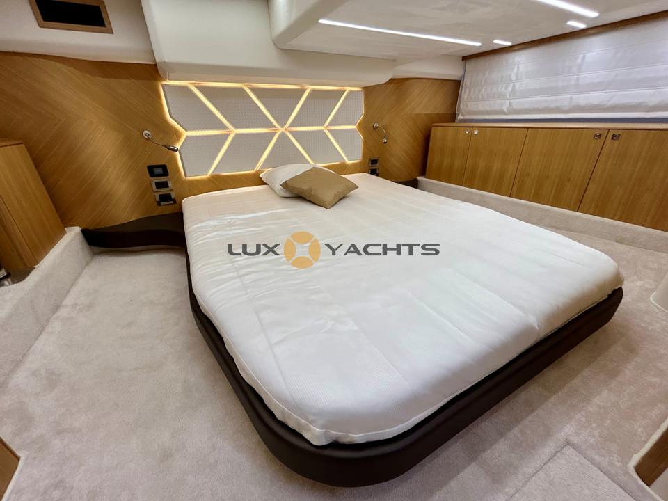 Luxurious bedroom interior of 2021 Galeon 400 Fly yacht with modern design and cozy bedding.