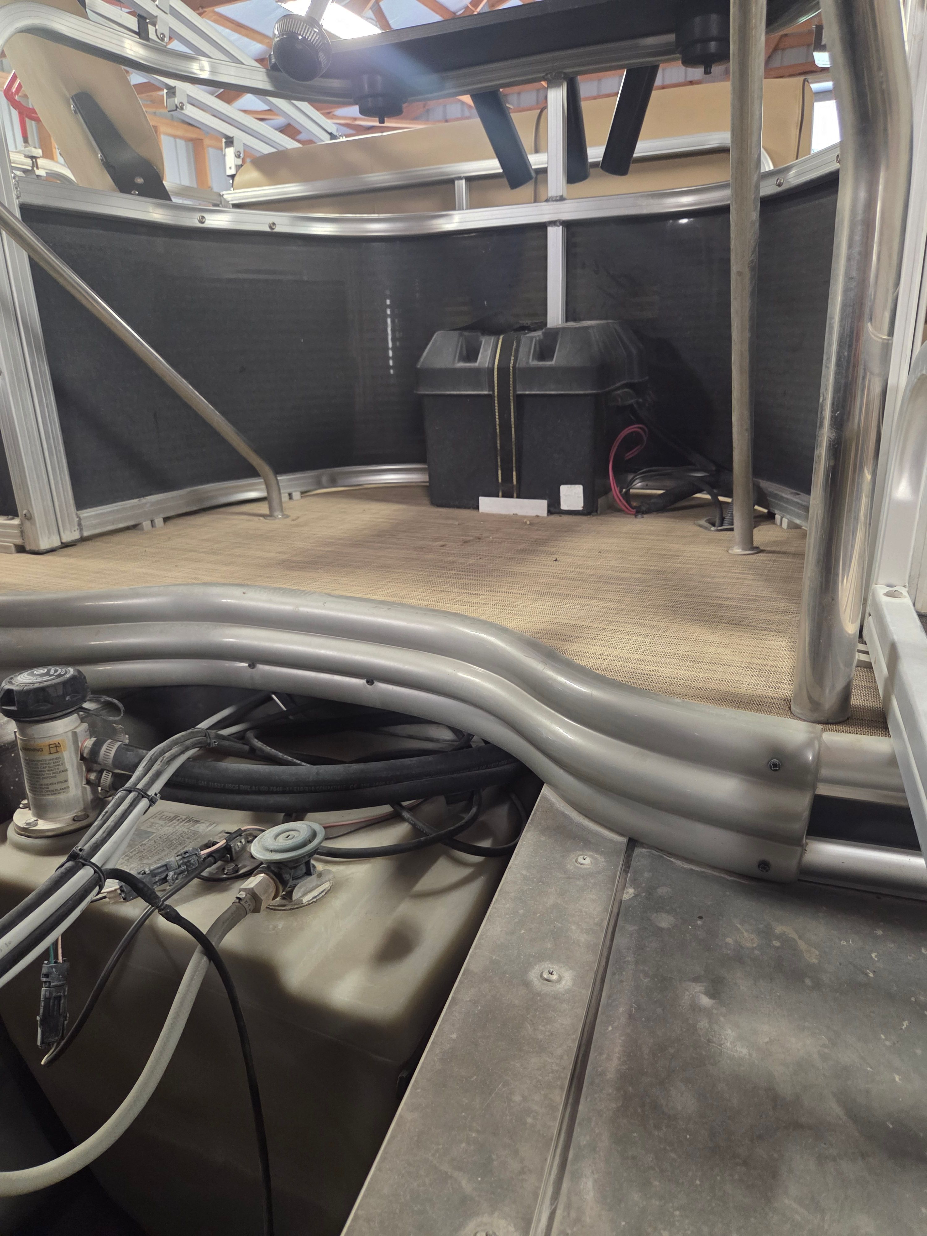 Interior view of a boat with metal railings and a battery.