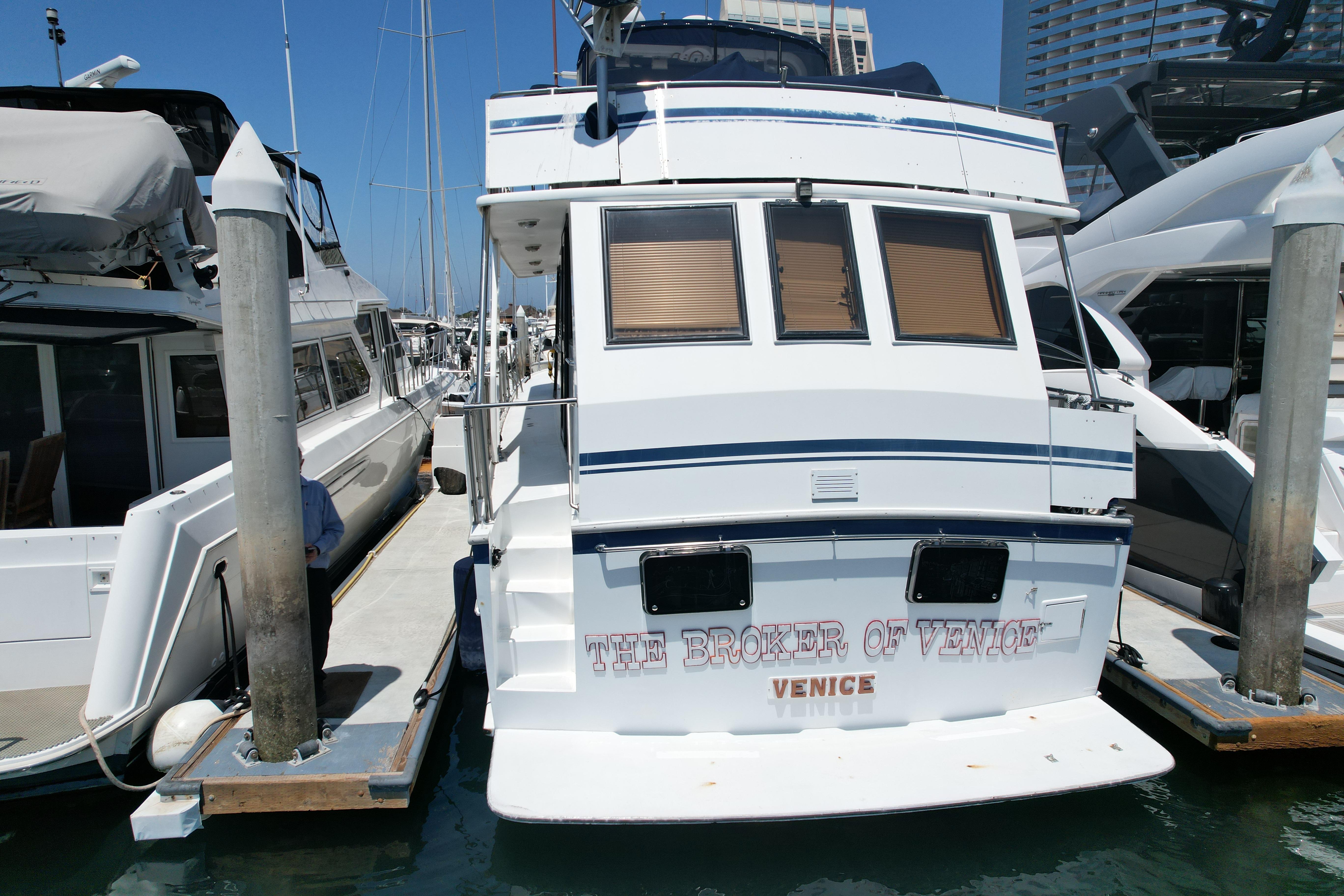 1988 Sea Ranger 51 Motor Yacht docked at marina, rear view with "The Broker of Venice" text.
