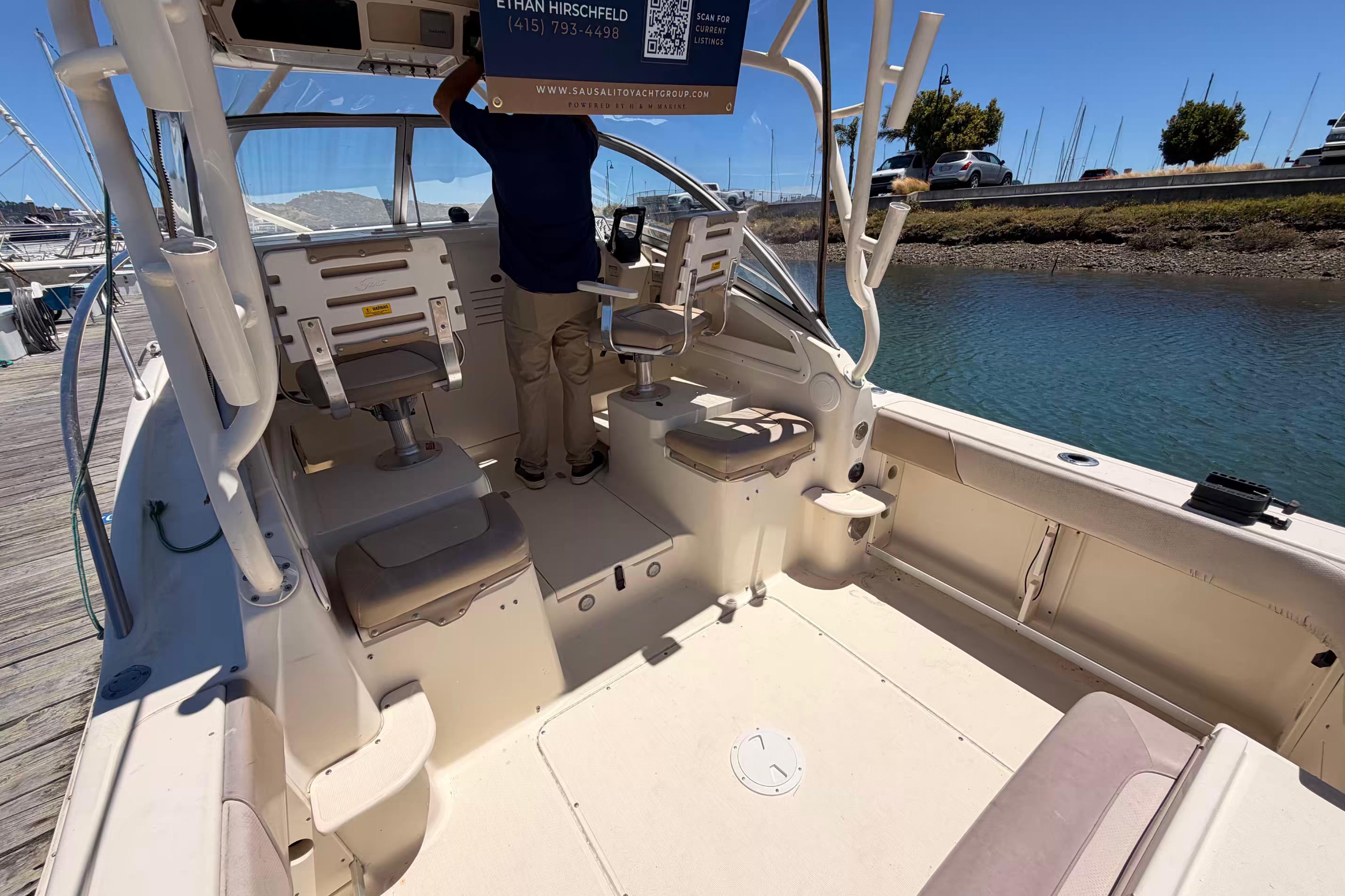 2007 Scout 262 Abaco boat interior at dock, featuring seating and helm area.