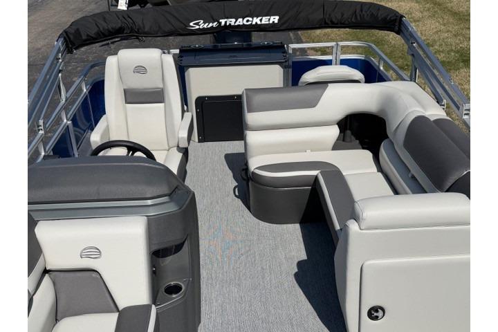 2026 Sun Tracker Fishin' Barge 20 DLX interior with plush seating and steering console.