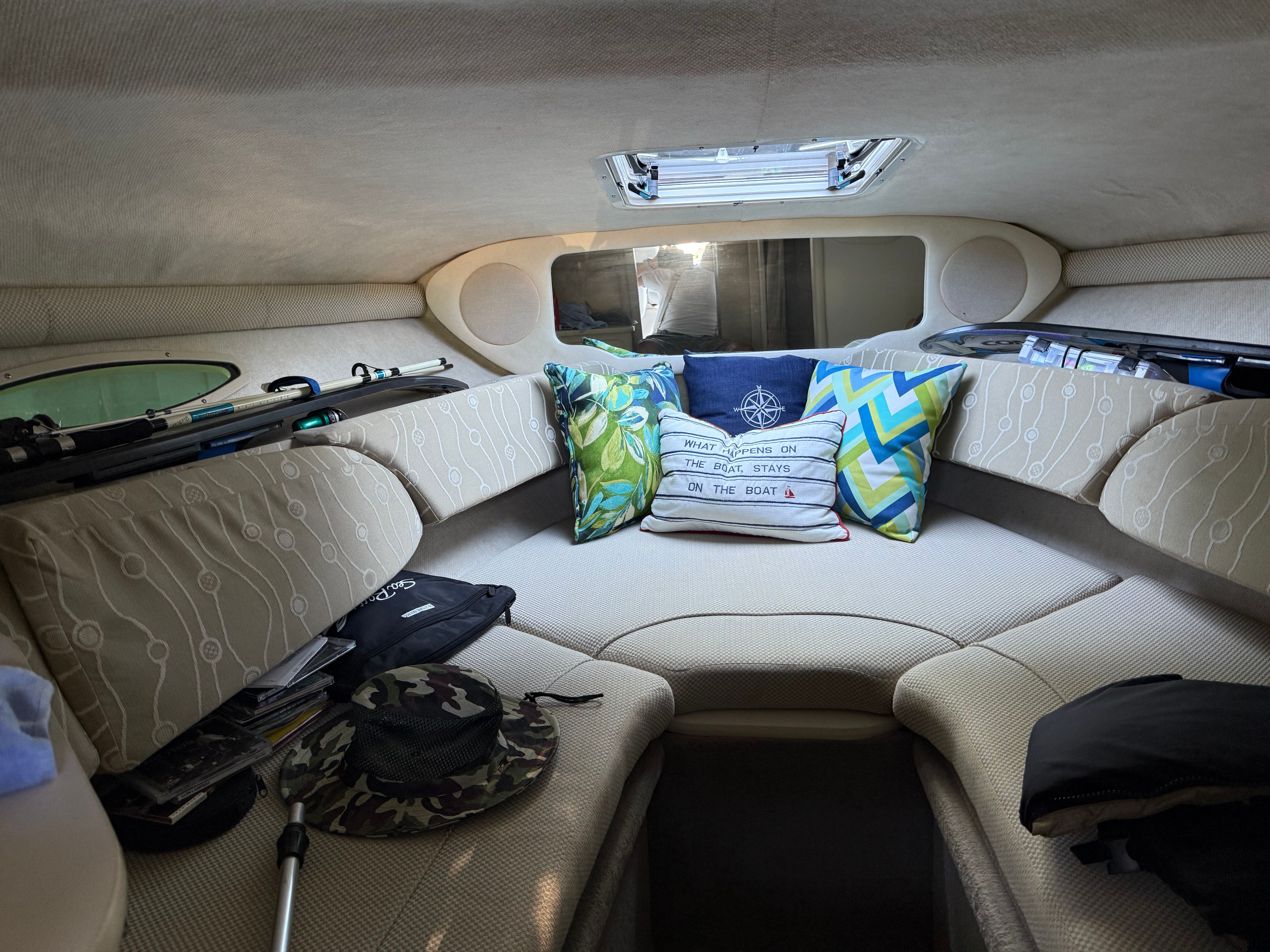 Interior of a 2006 Sea Ray 215 Weekender yacht, cozy with decorative pillows.