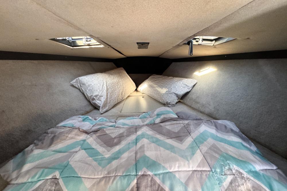 Cozy cabin interior of 1989 Formula 292 SR-1 boat with bedding and pillows.