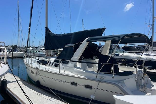 Sailboat docked at marina, 1997 Hunter 430 model, under clear blue sky.