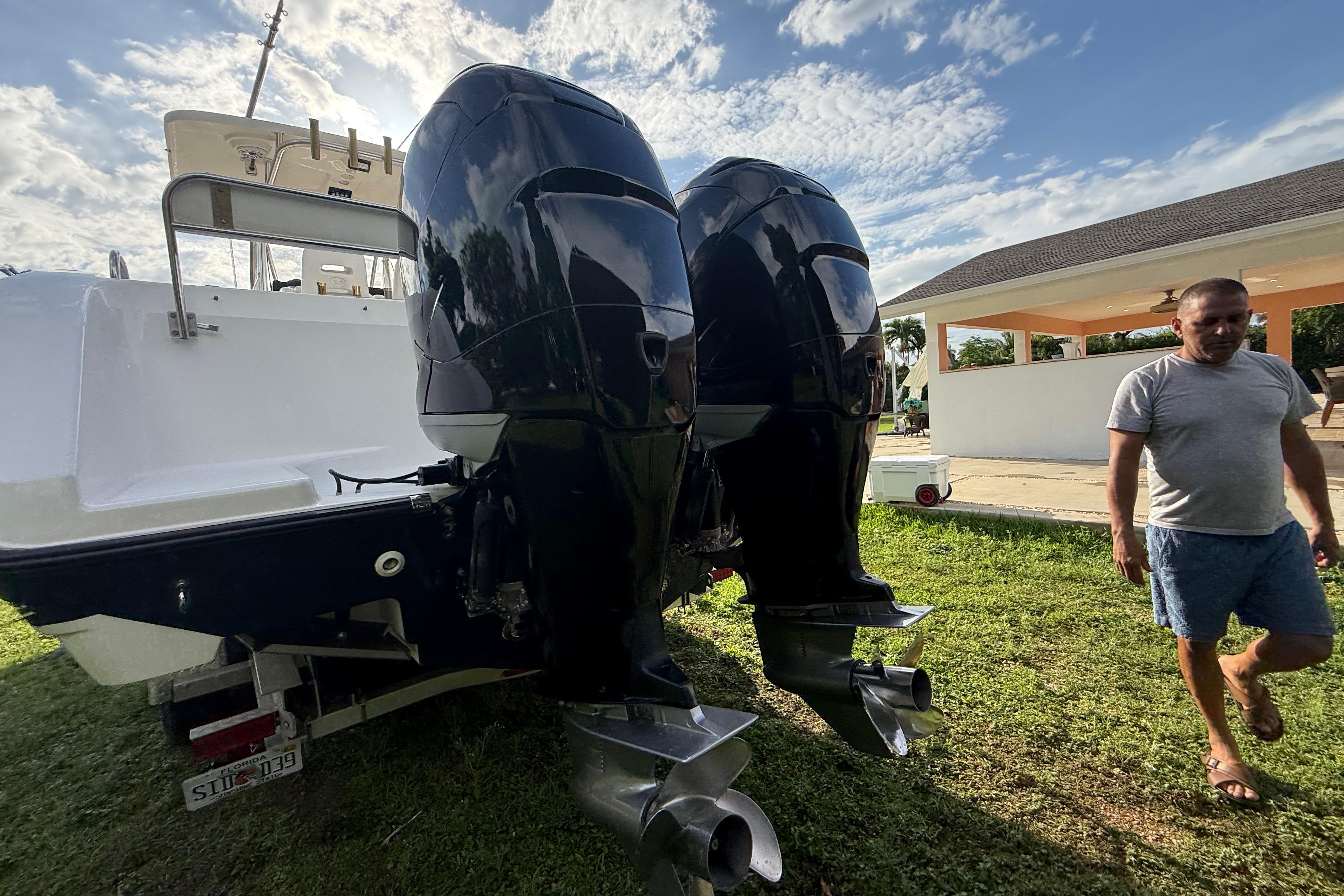 2007 Century 3200 Center Console boat with dual outboard motors on grass.