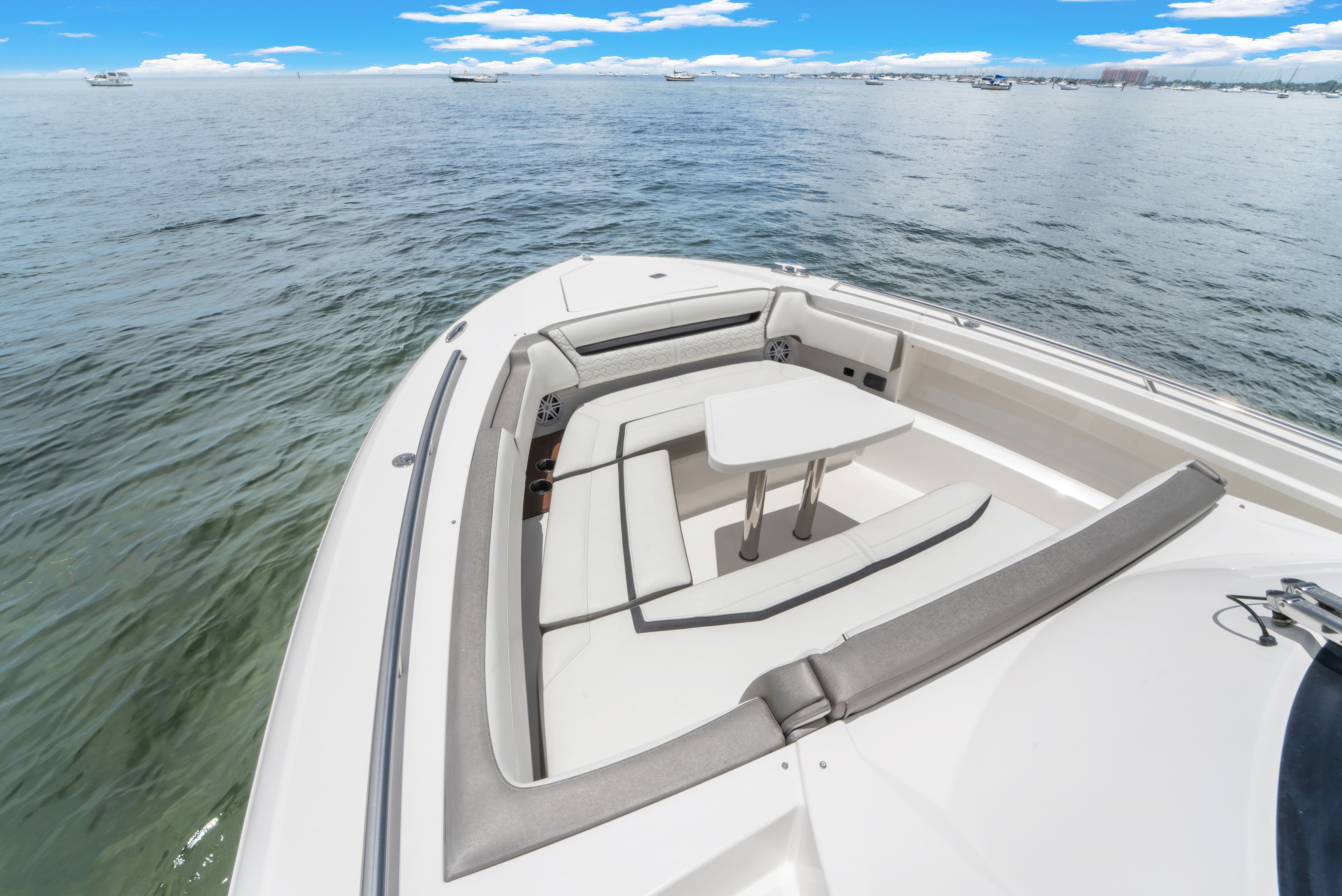 The 2023 Tiara Yachts 38 LS features a sleek seating area with a table on the bow.