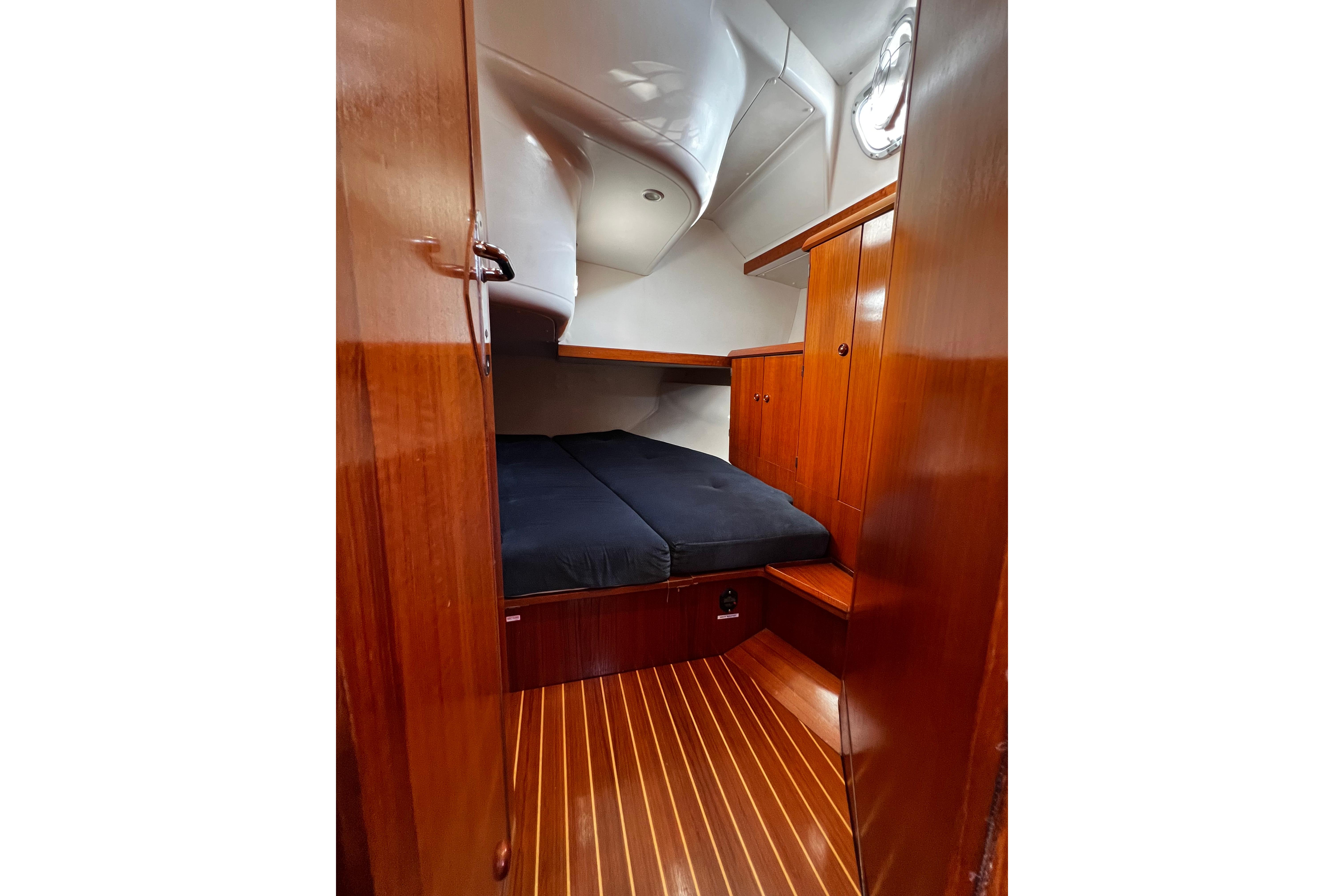 Cozy cabin interior of 1995 Jeanneau Sun Odyssey 45.1 sailboat with wooden finish.