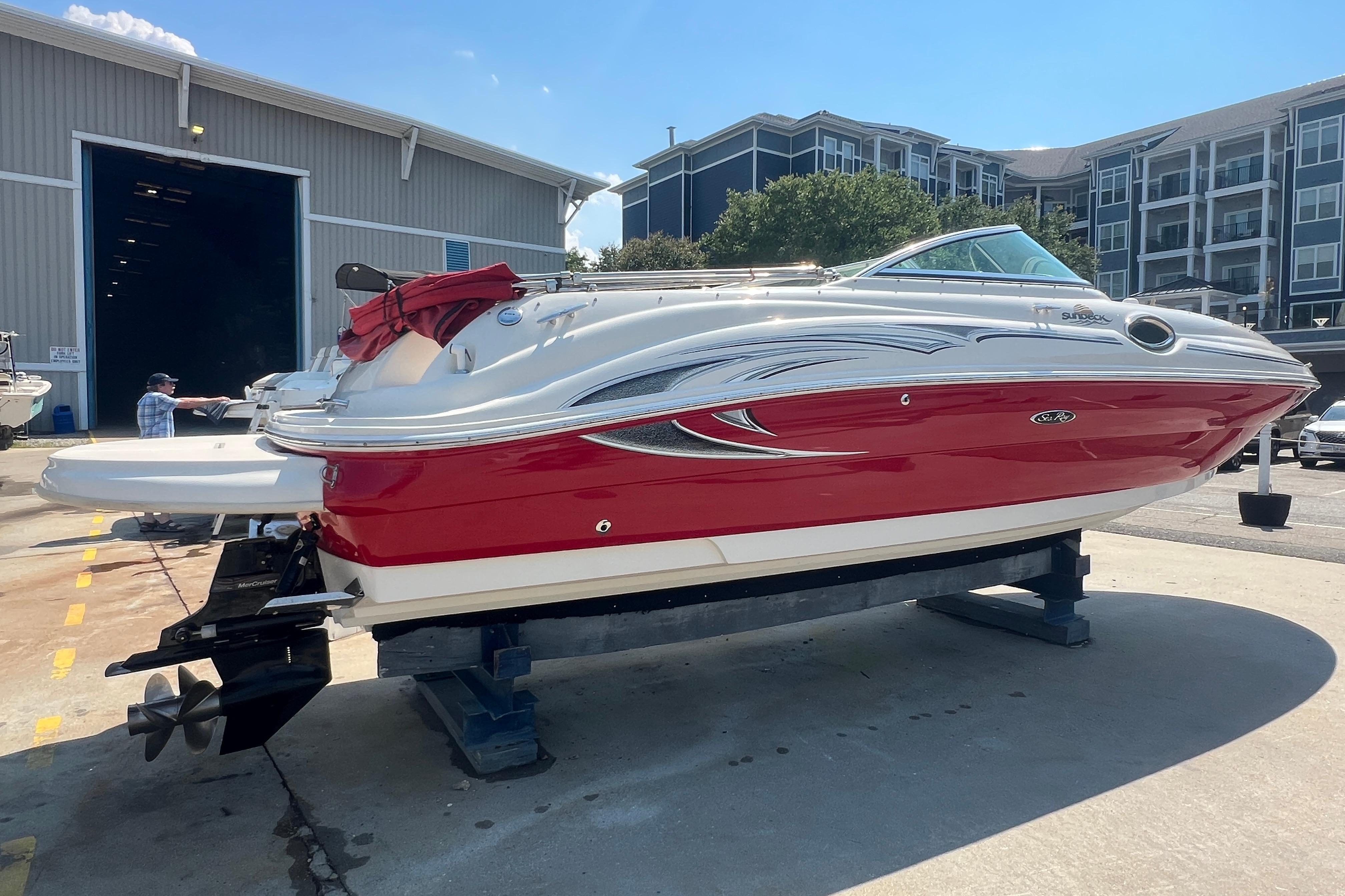 2005 Sea Ray 240 Sundeck boat with red and white exterior on a lift.