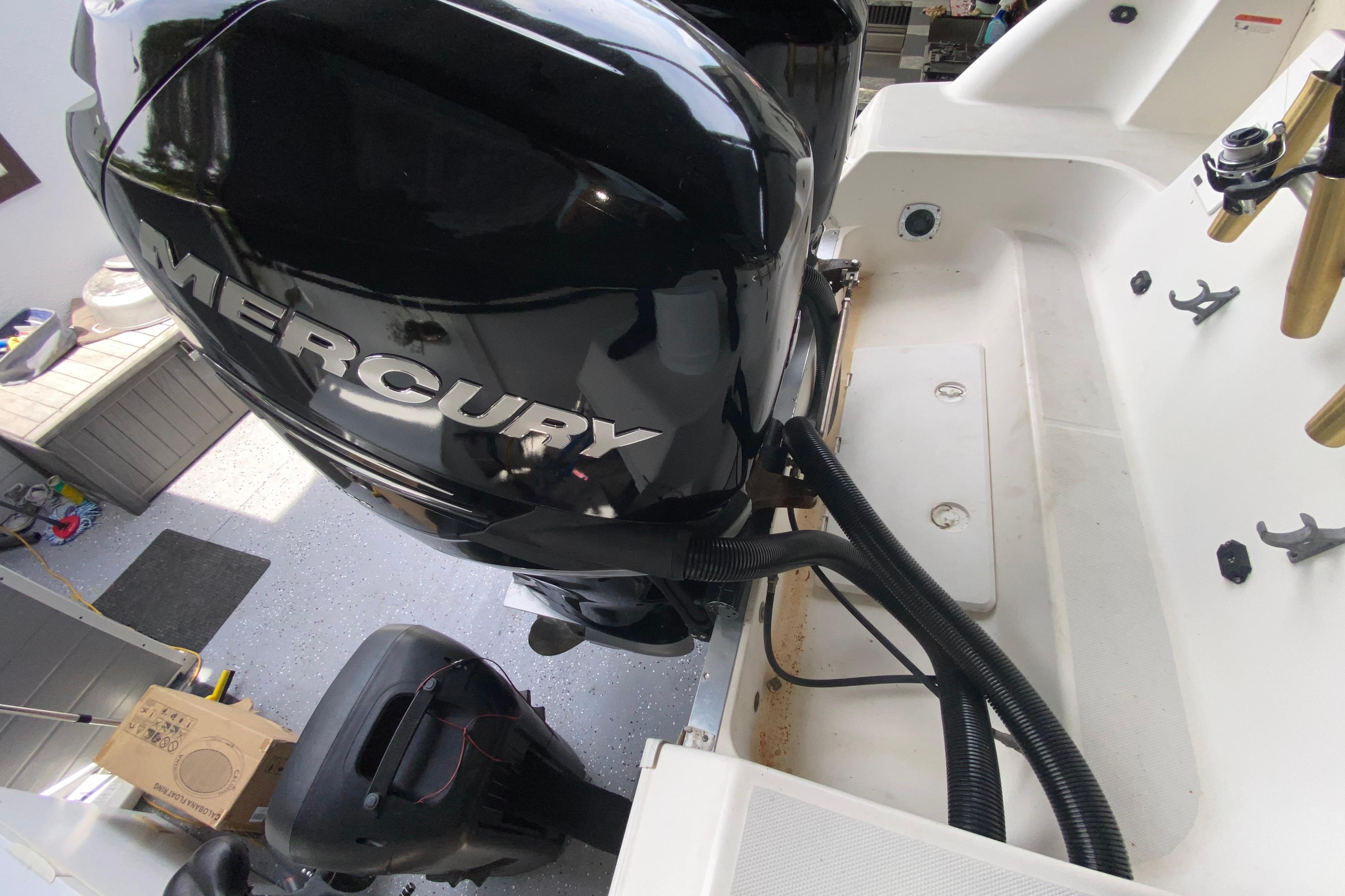 2005 Wellcraft 290 Coastal boat with Mercury outboard engine in a garage setting.