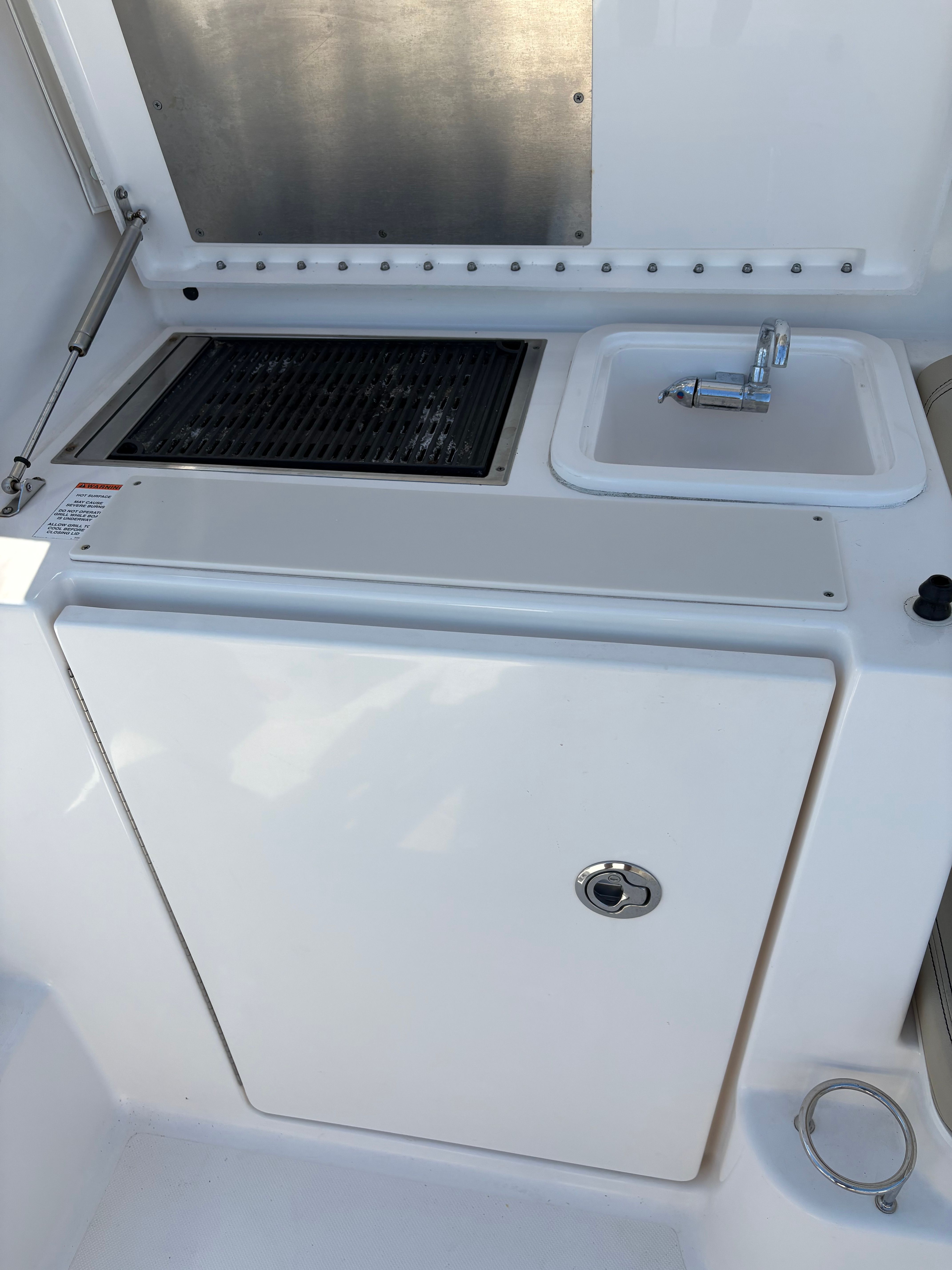 2017 Pursuit OS 355 Offshore boat kitchenette with grill and sink.