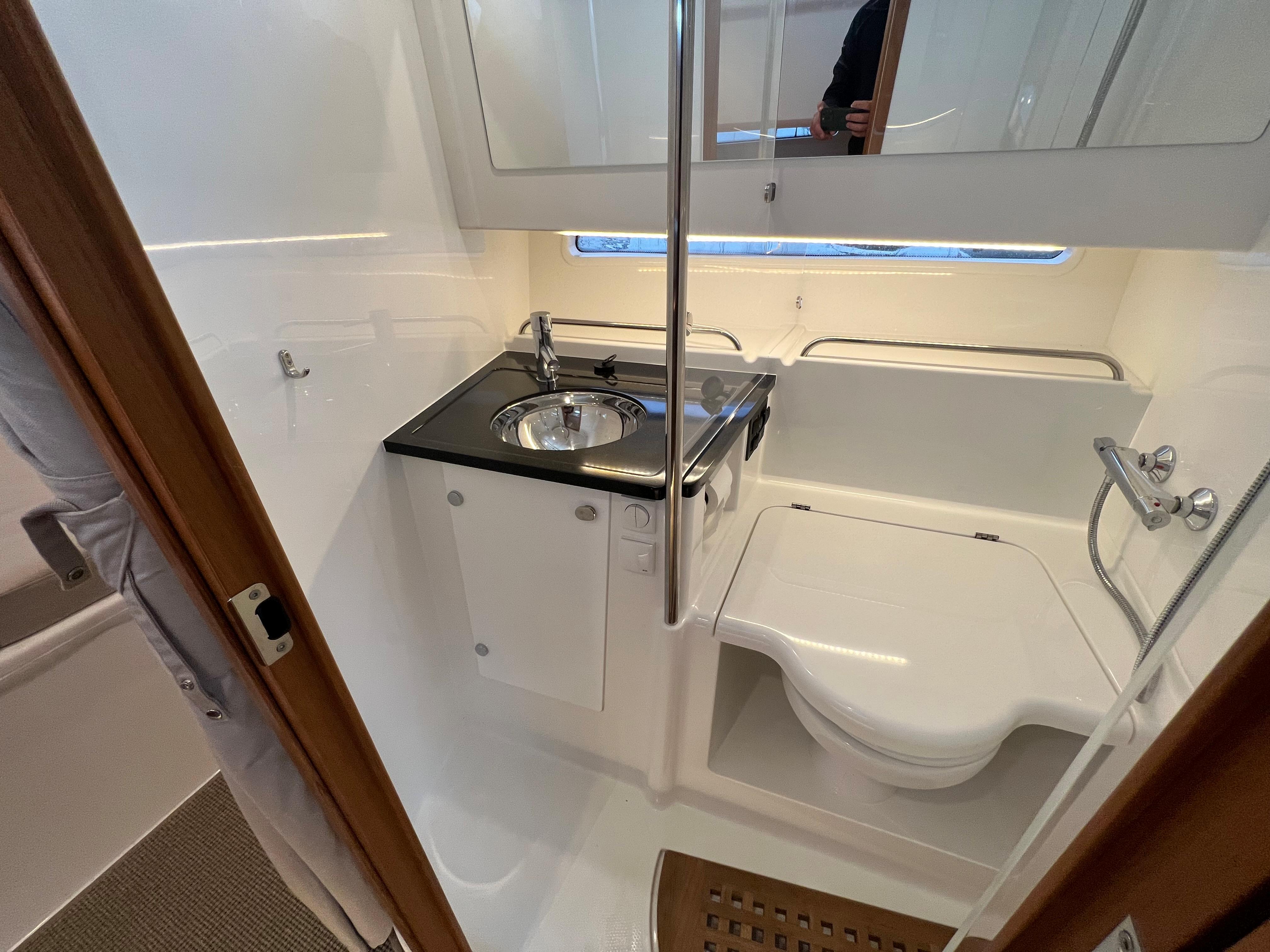 Compact bathroom in 2021 Nimbus Tender 11 boat with sink, toilet, and shower.