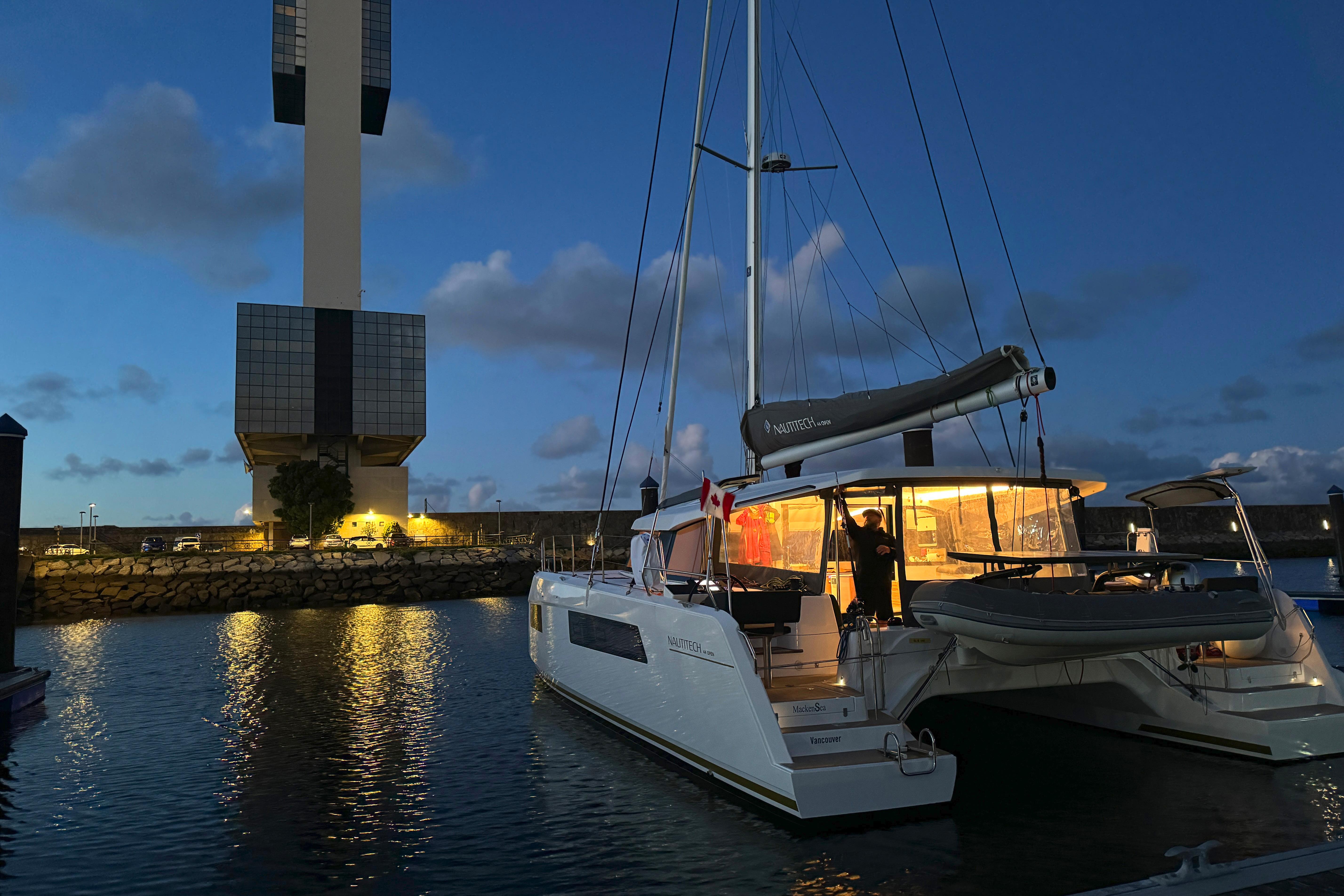 2024 Nautitech 44 Open catamaran docked at night, illuminated with warm interior lights.
