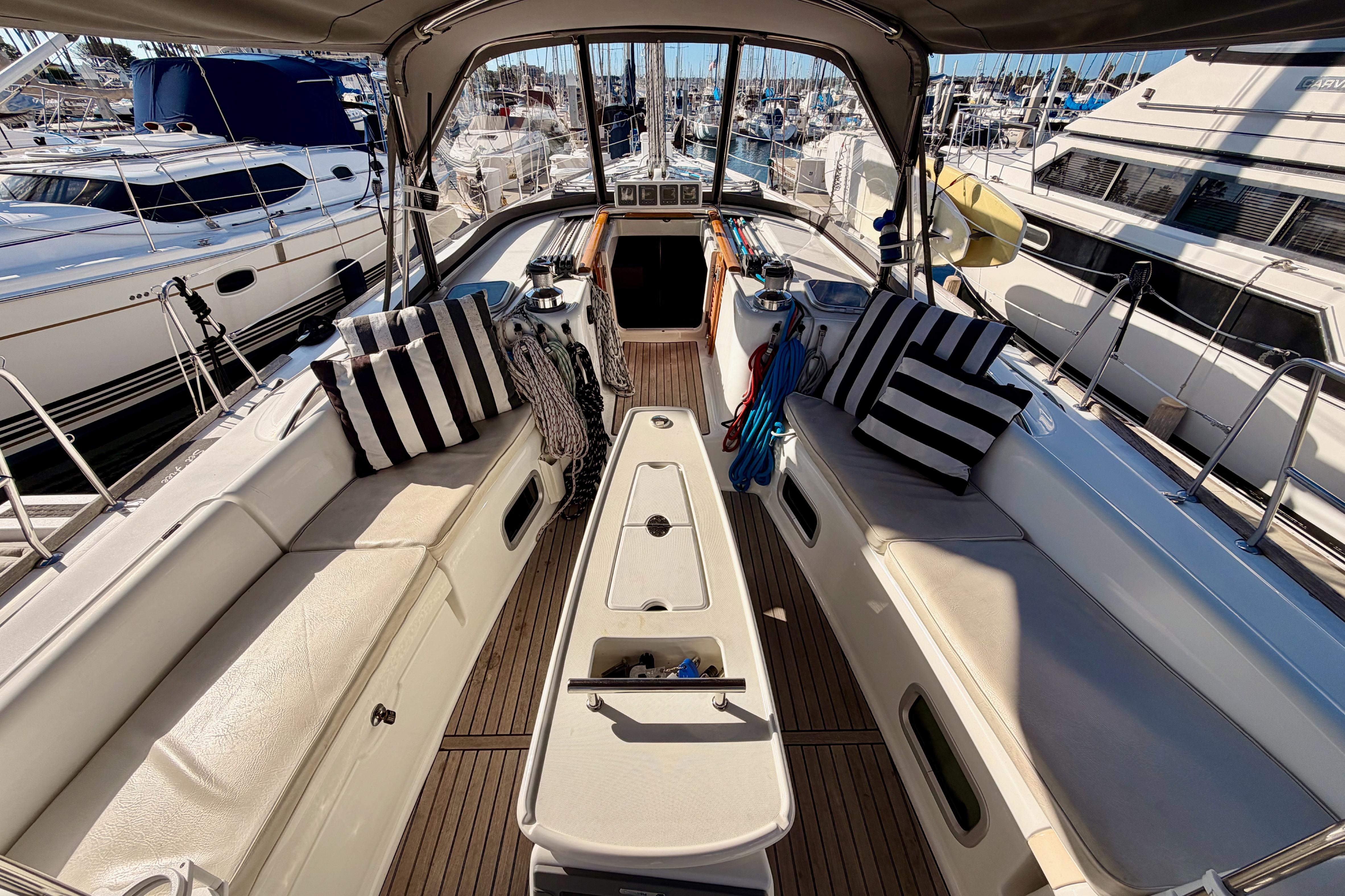2007 Beneteau 49 yacht cockpit with striped cushions, docked in marina.