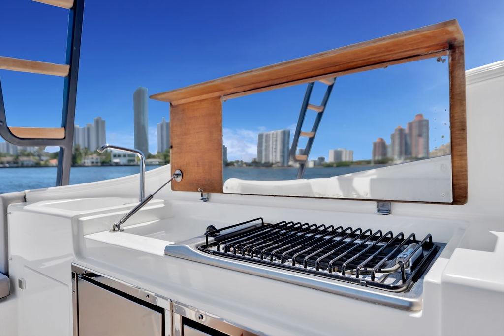 Outdoor kitchen on 2021 Bluegame BG 42 yacht with city skyline view.