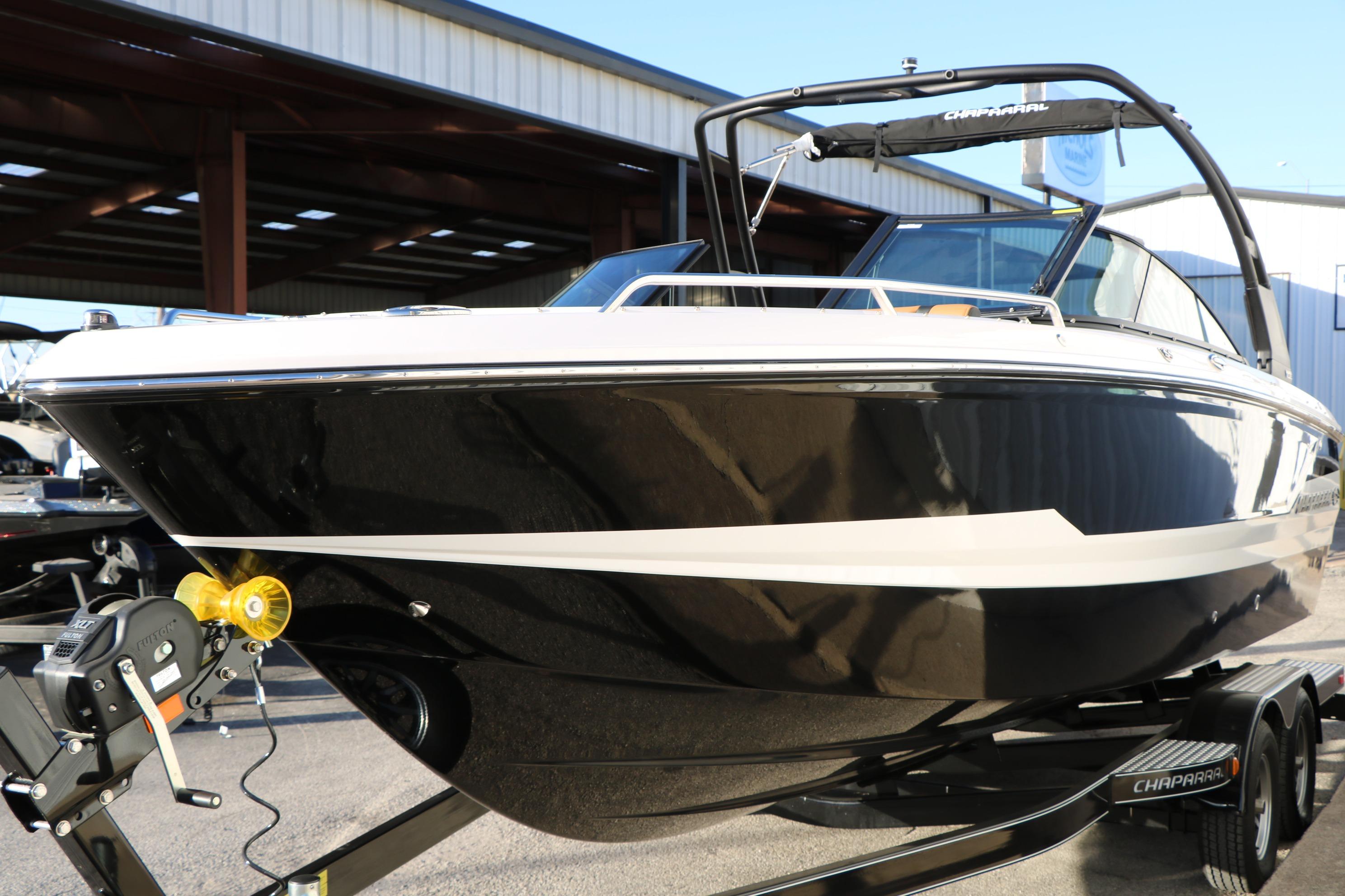 2026 Chaparral 247 SSX boat on trailer, sleek black and white design.