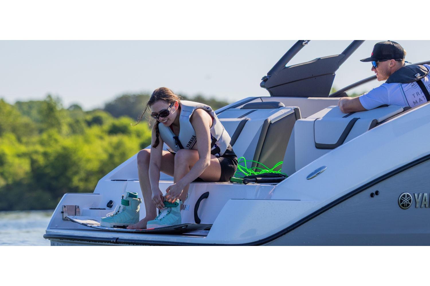 2026 Yamaha Boats AR220 with people preparing for water activities on a sunny day.