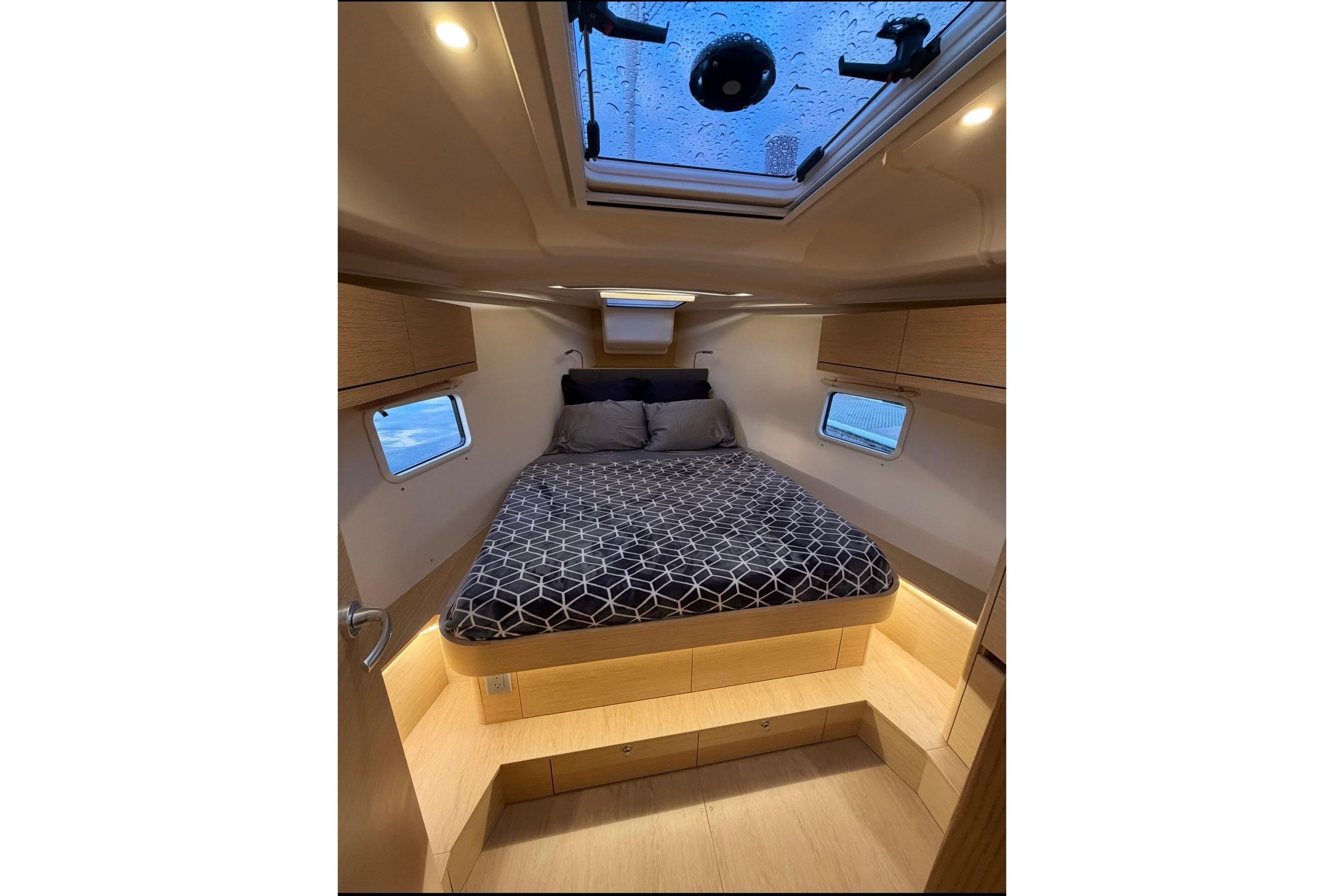 Cozy cabin interior of 2022 Hanse 418 yacht with skylight and modern bedding.
