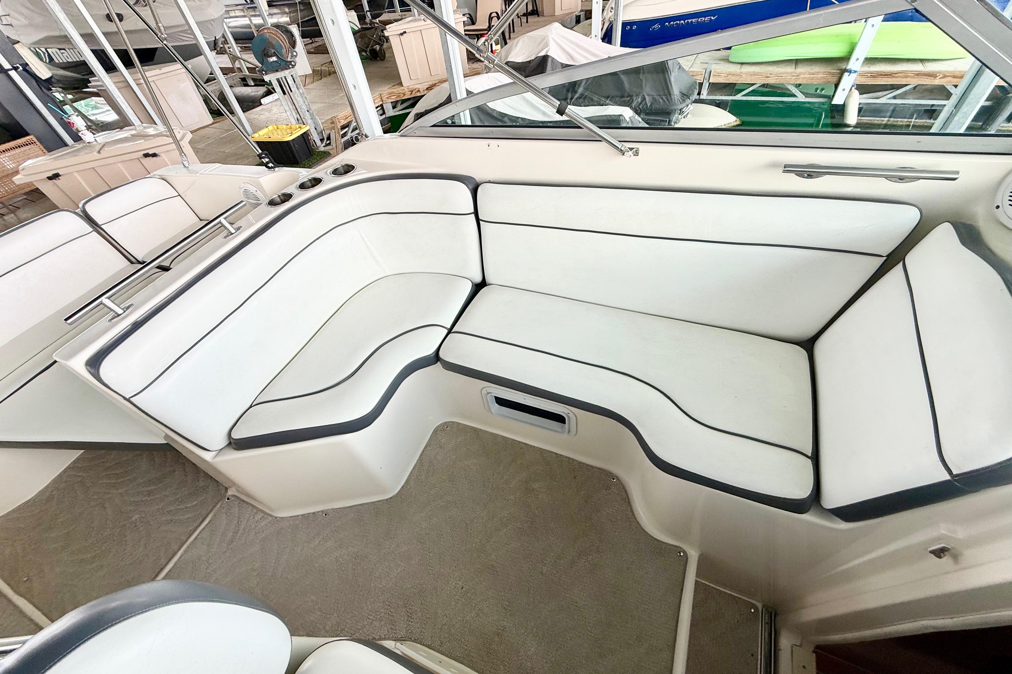 2005 Rinker 270 Express Cruiser interior with white cushioned seating and sleek design.