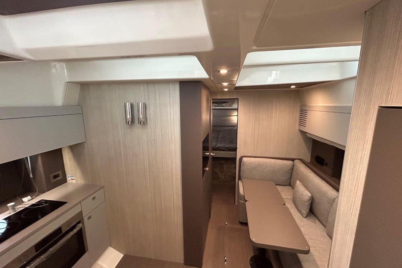 Luxurious interior of 2025 Cranchi M44HT yacht with modern kitchen and cozy seating area.