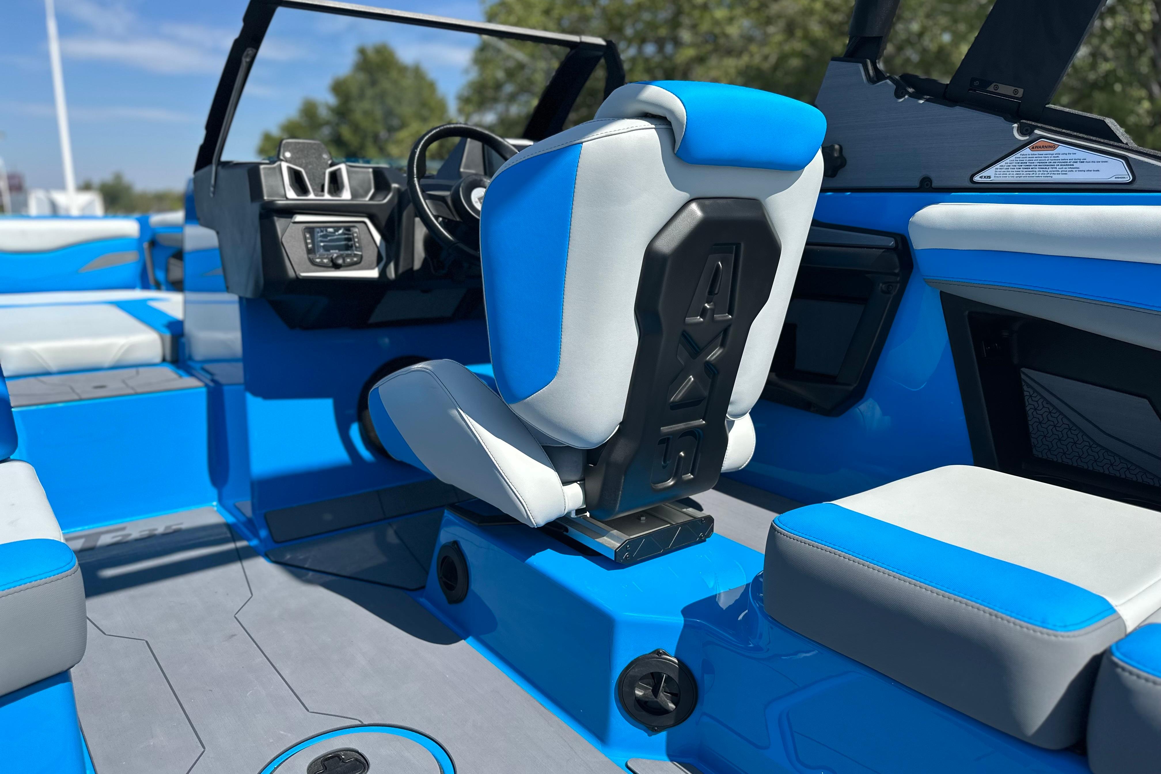 2026 Axis T235 boat interior with blue and white seating, modern dashboard, and steering wheel.