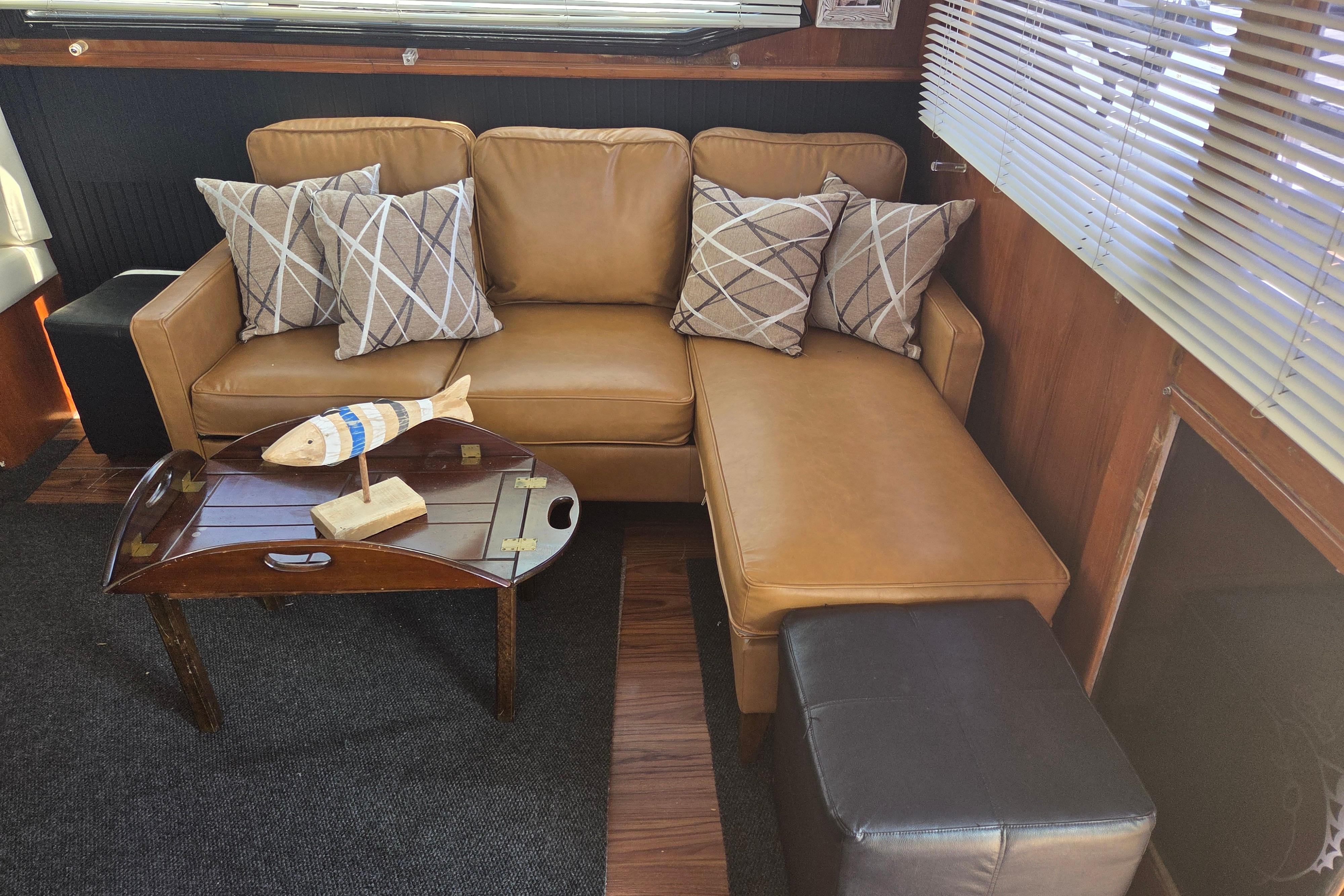 Luxurious interior of 1990 Egg Harbor Golden Egg 42 yacht with leather sofa and decorative pillows.