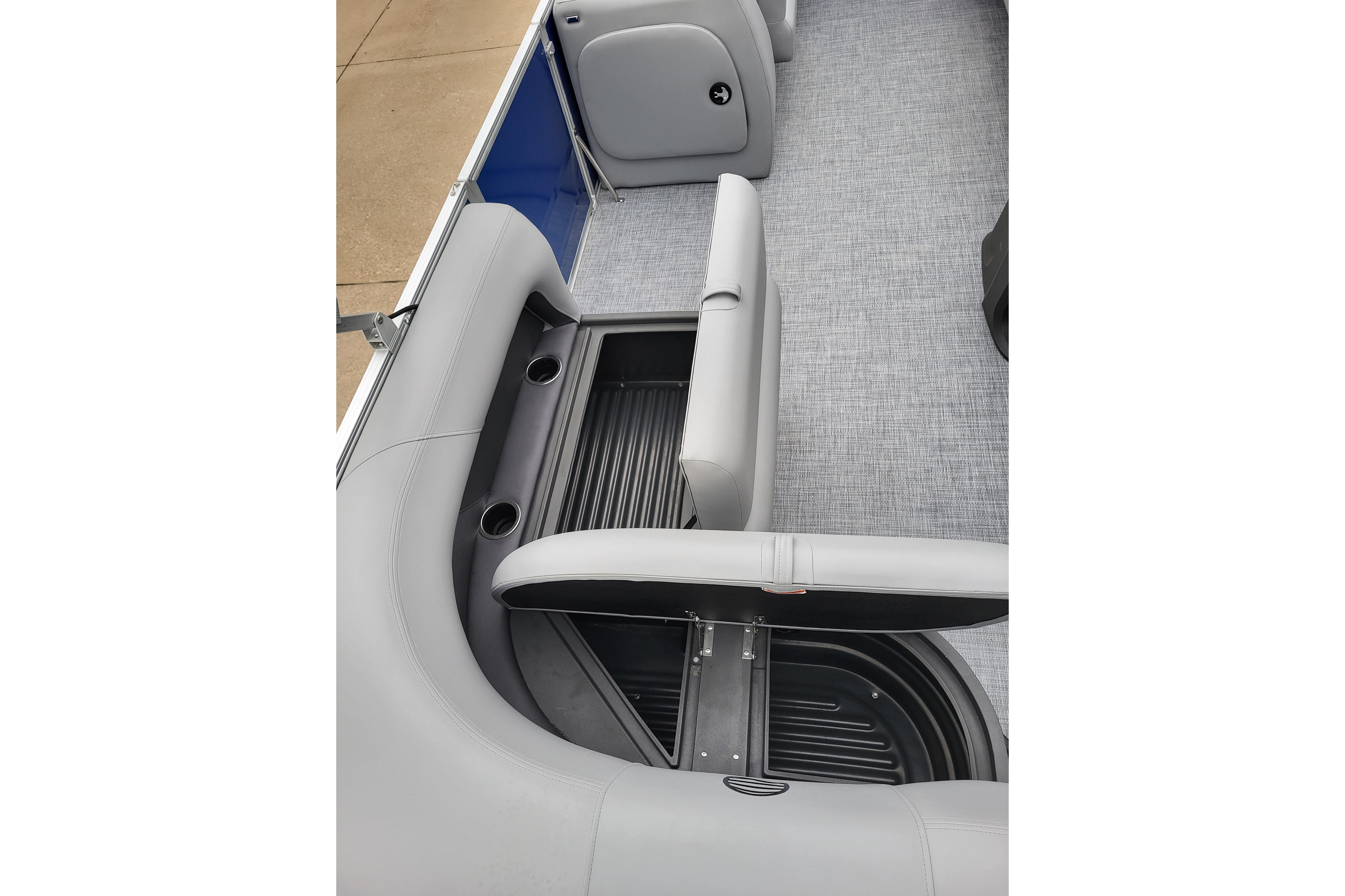 2026 Sun Tracker Party Barge 18 DLX interior with open storage compartment and cup holders.