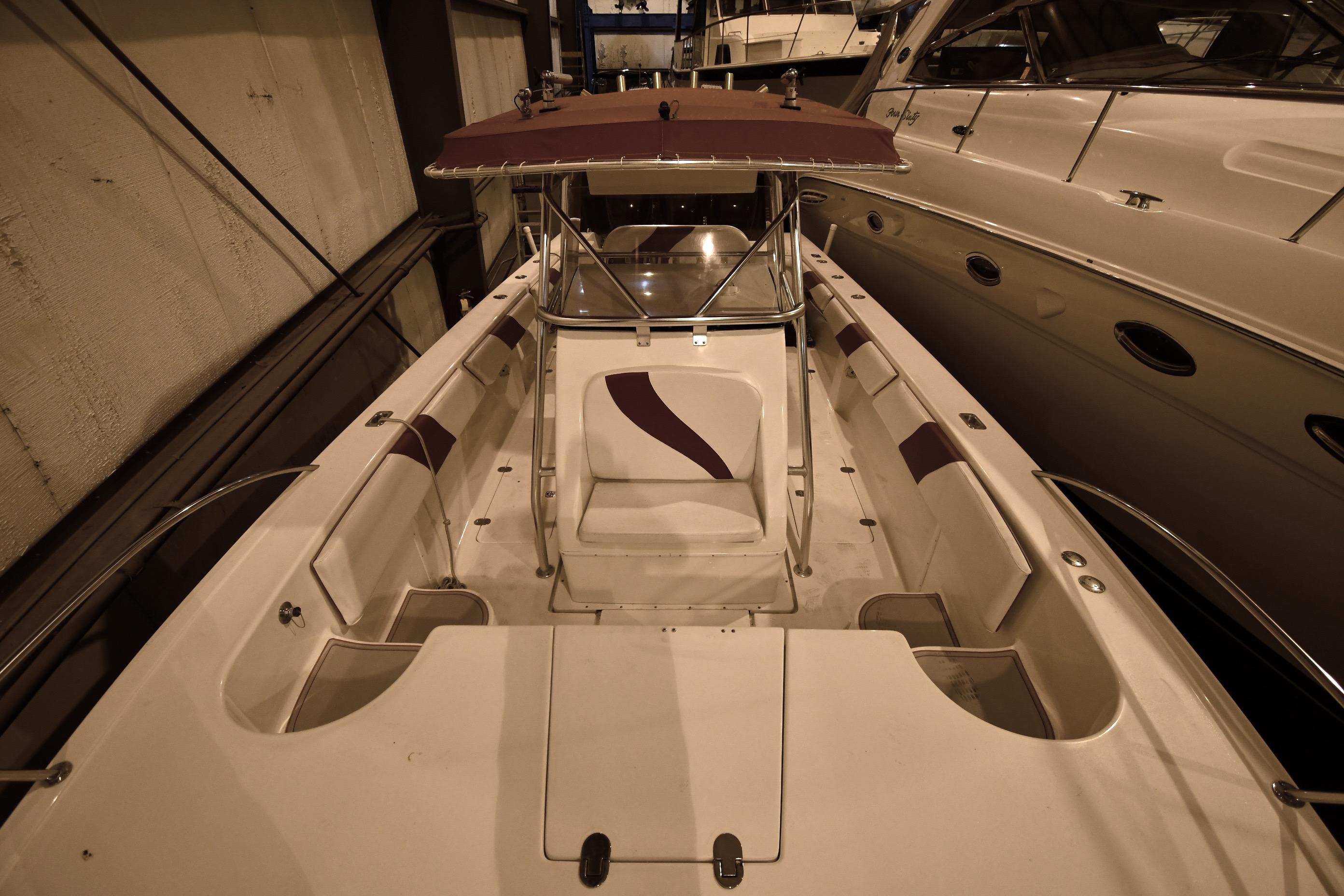 2001 Fountain 38 Center Console boat with maroon accents, docked indoors.