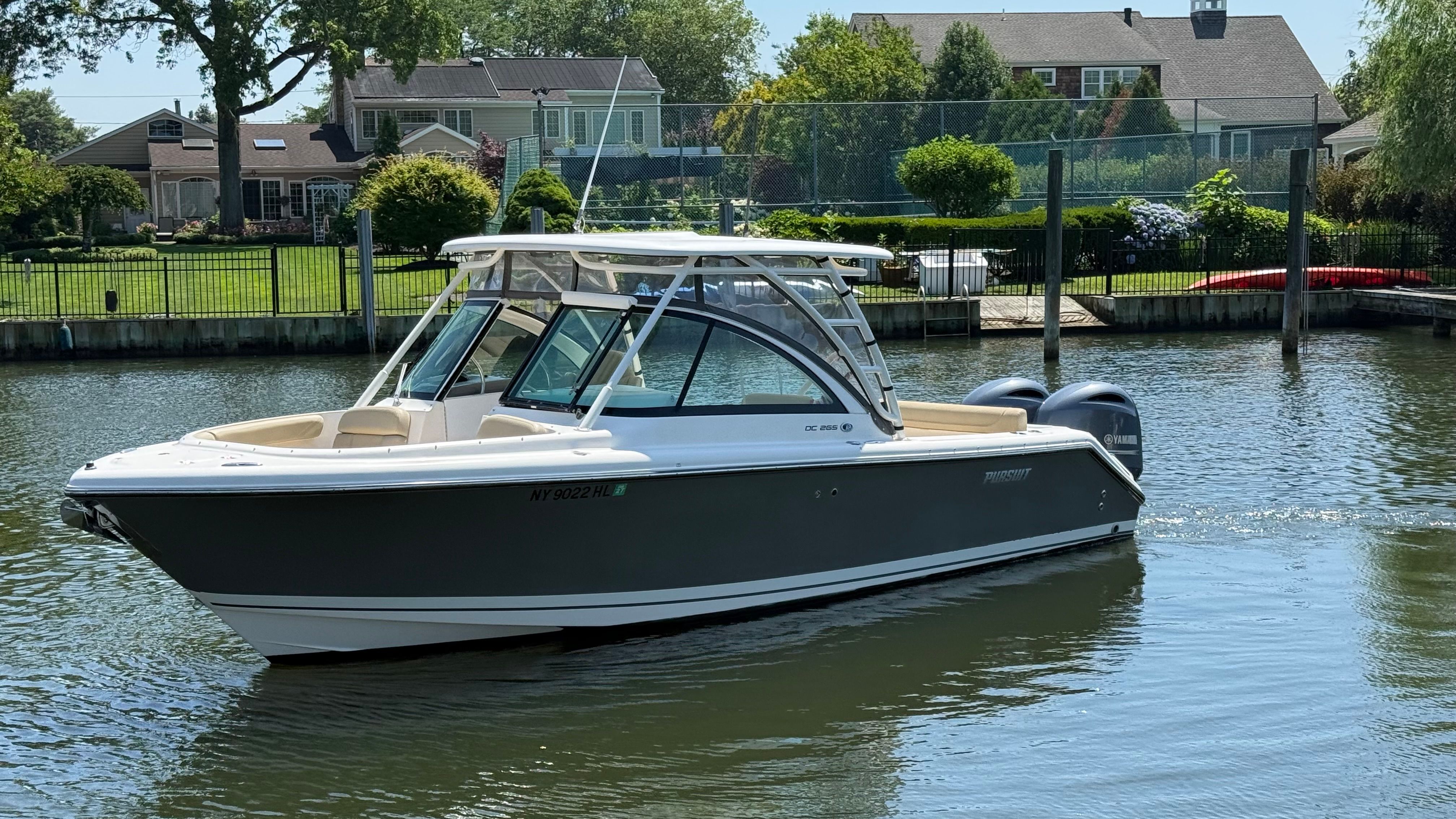 A 2016 Pursuit DC 265 Dual Console boat cruising on calm water.