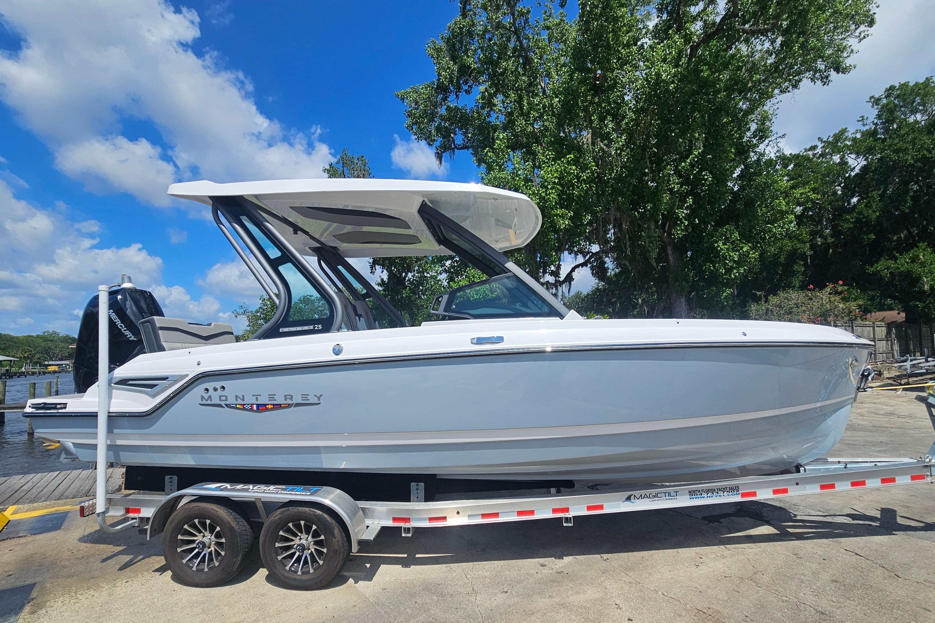 2026 Monterey Elite 25 OB boat on trailer, under clear blue sky.