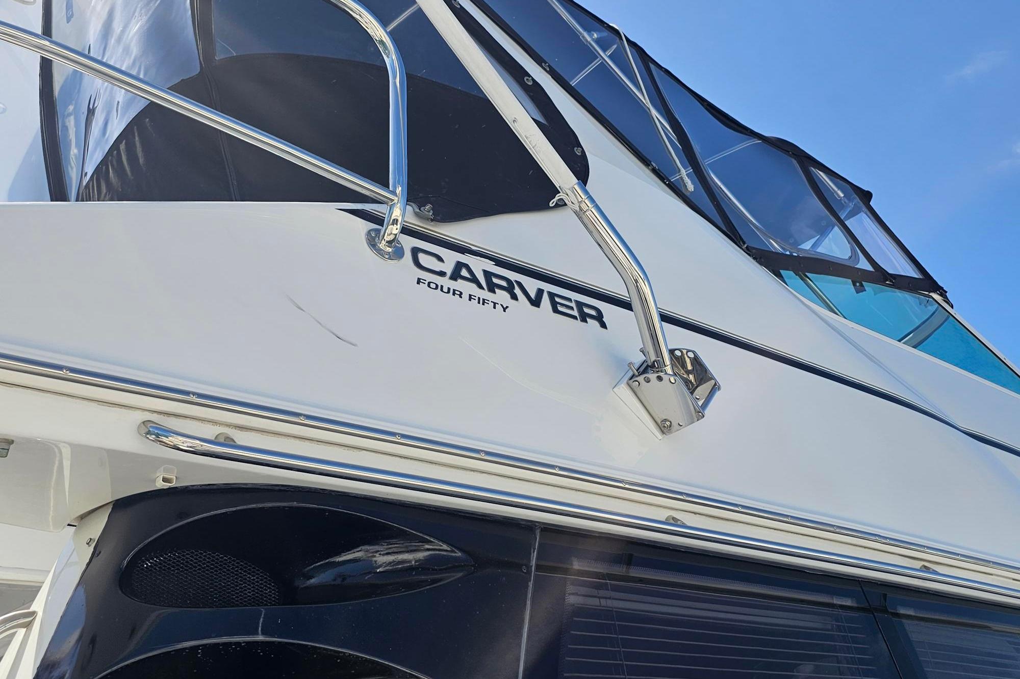 2002 Carver 450 Voyager Pilothouse yacht, sleek design, blue sky background.