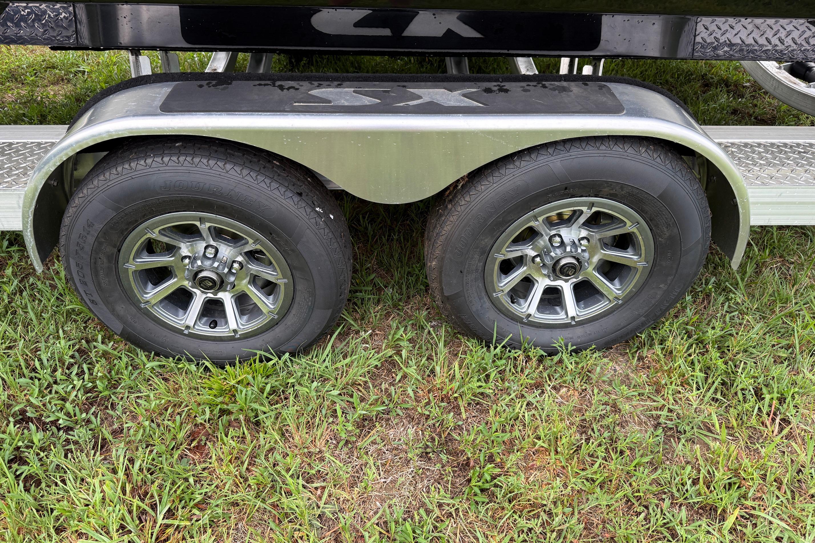 Trailer wheels of a 2026 Skeeter SX2350 boat on grass.