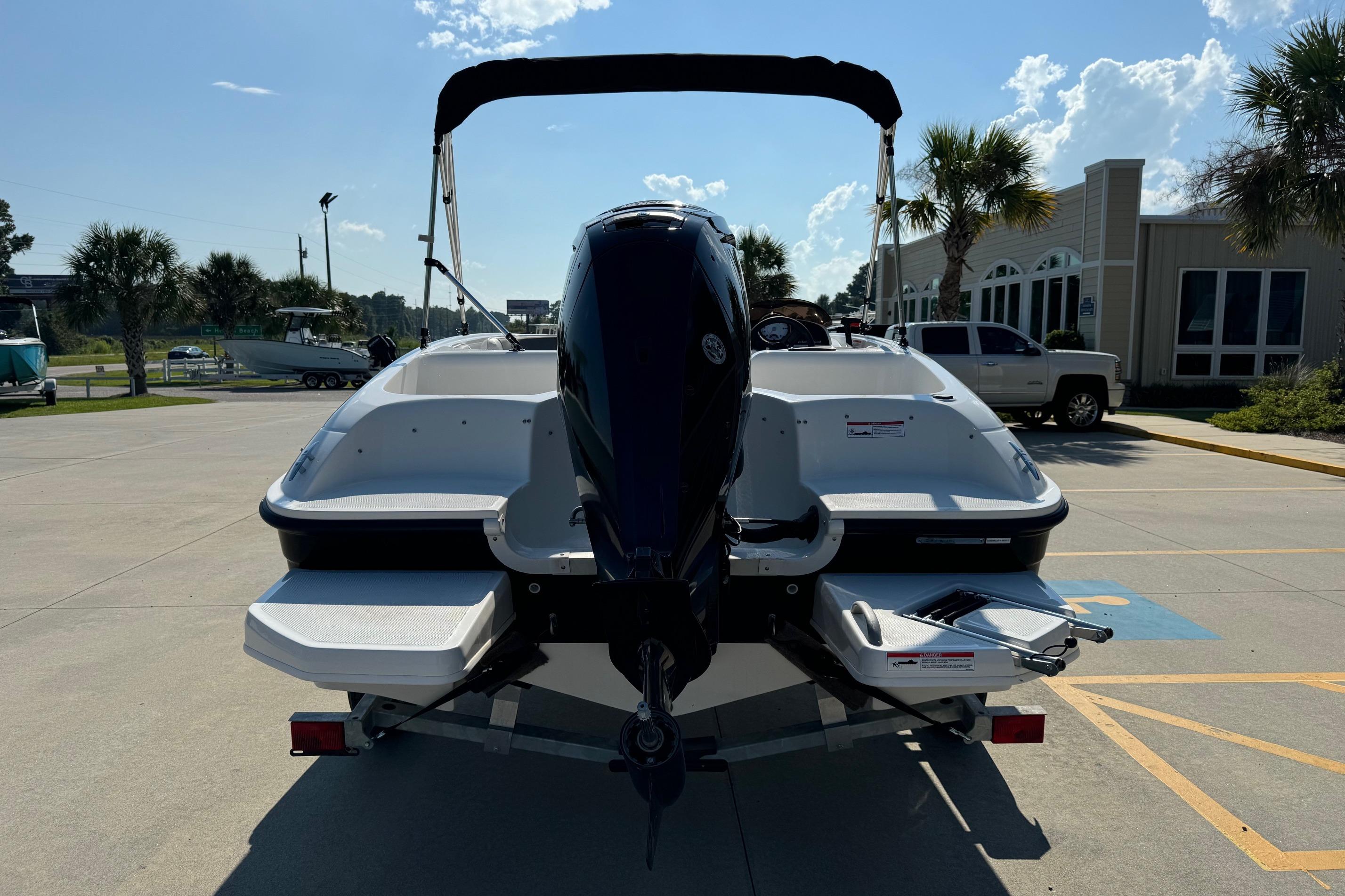 2025 Bayliner Element E16 boat on trailer, parked outdoors under sunny sky.