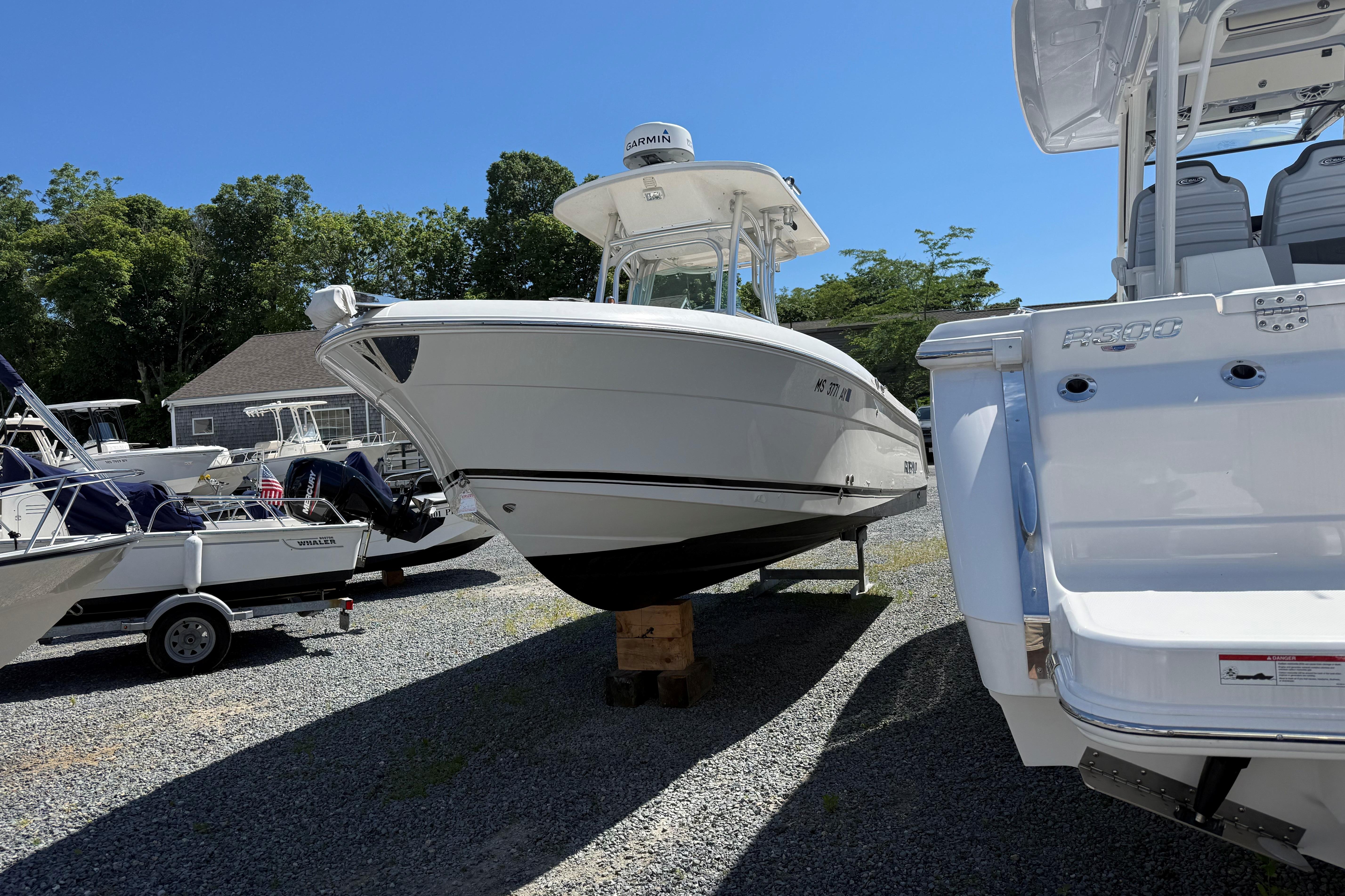 2009 Robalo R240 Center Console boat displayed outdoors on gravel lot.