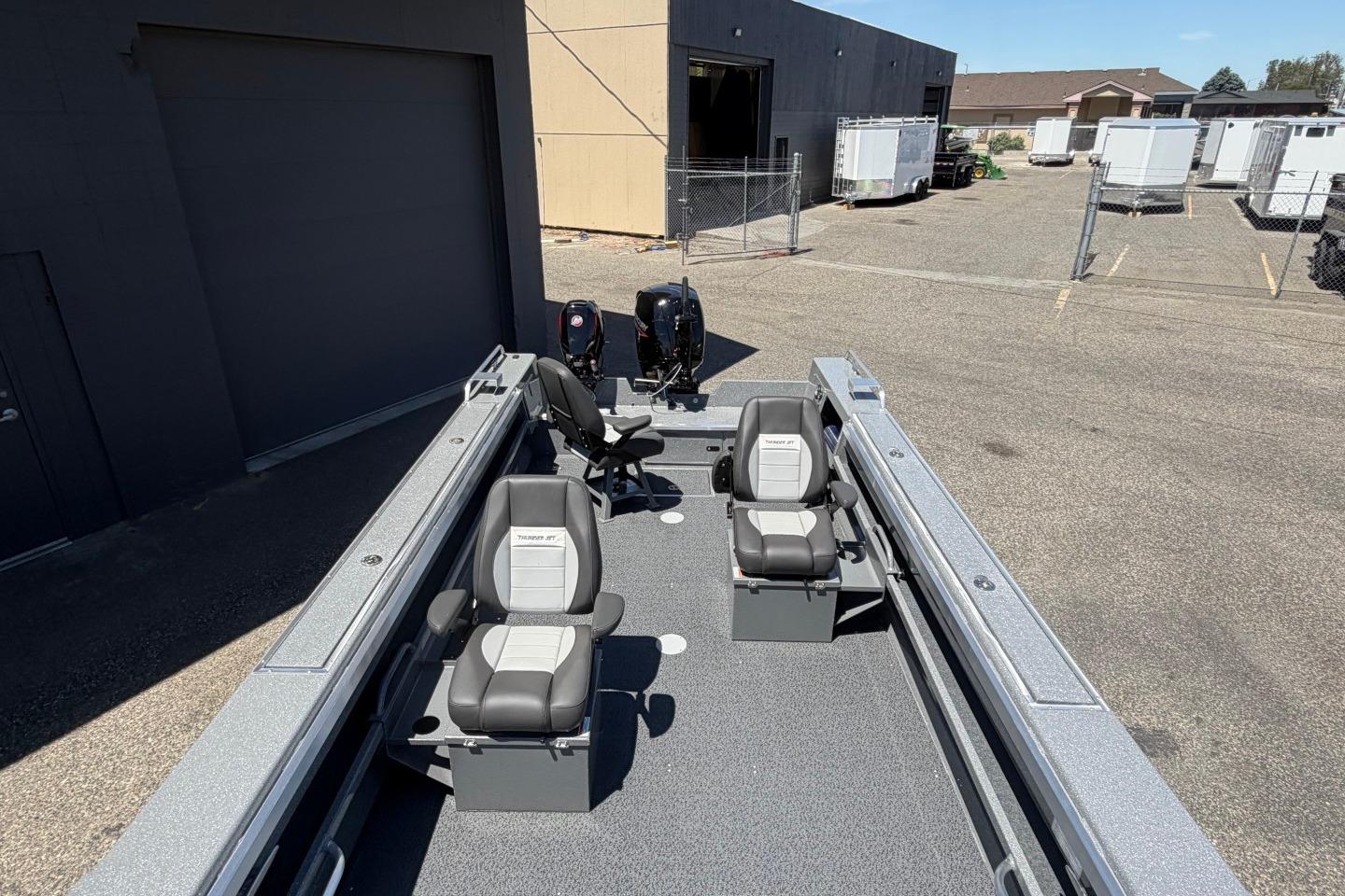 2026 Thunder Jet 209 Rush OT boat with dual seats and outboard motors in a parking area.