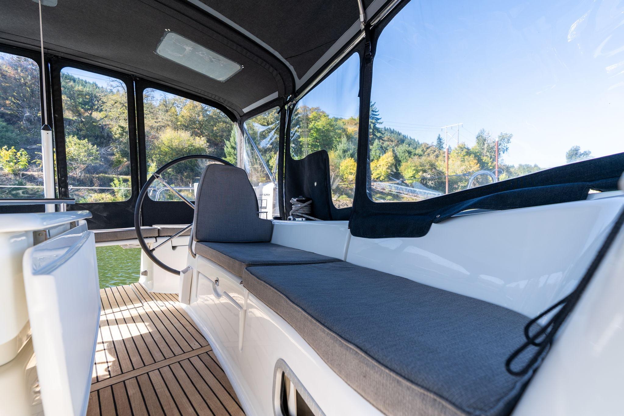 Cockpit of 2013 Beneteau Oceanis 50 sailboat with cushioned seating and steering wheel.