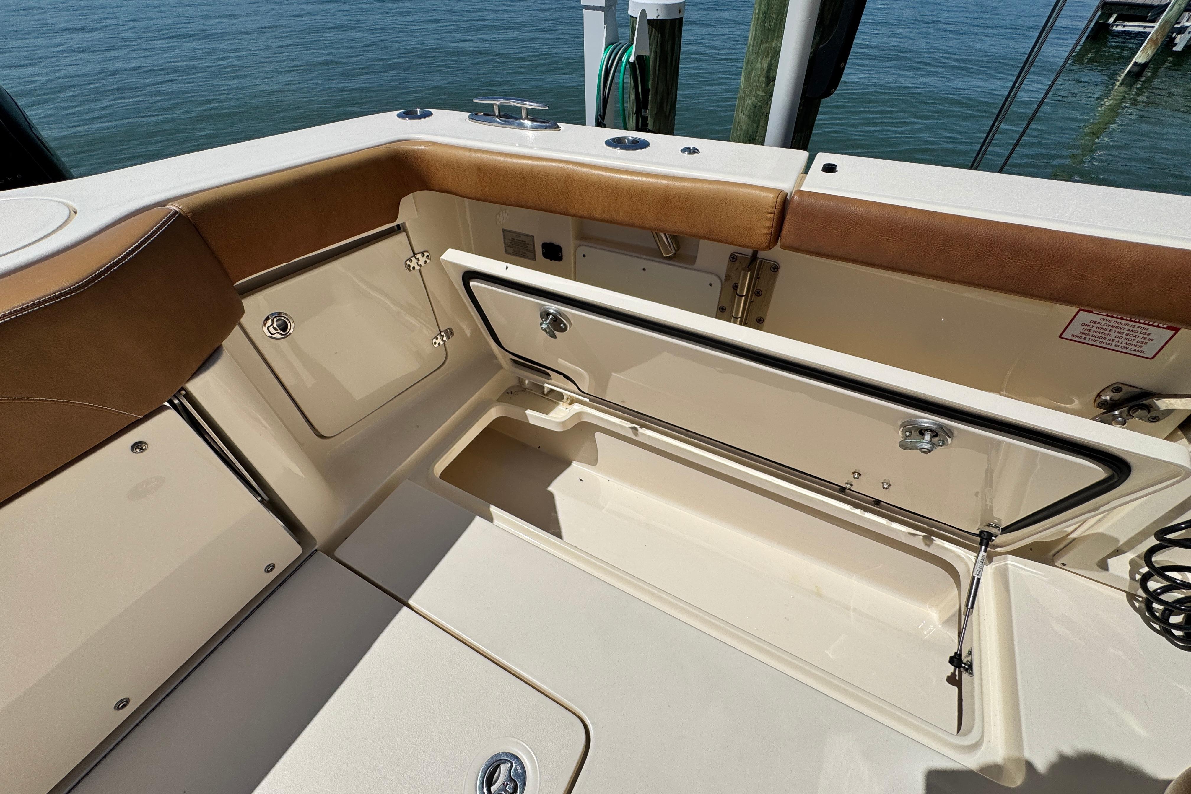 2018 Scout 355 LXF boat interior with open storage compartment by the water.