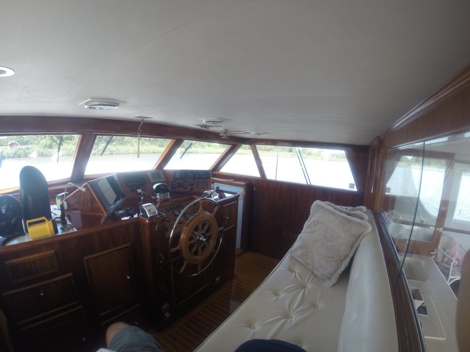 Interior of a 1963 Burger Flush Deck yacht with steering wheel and sofa.