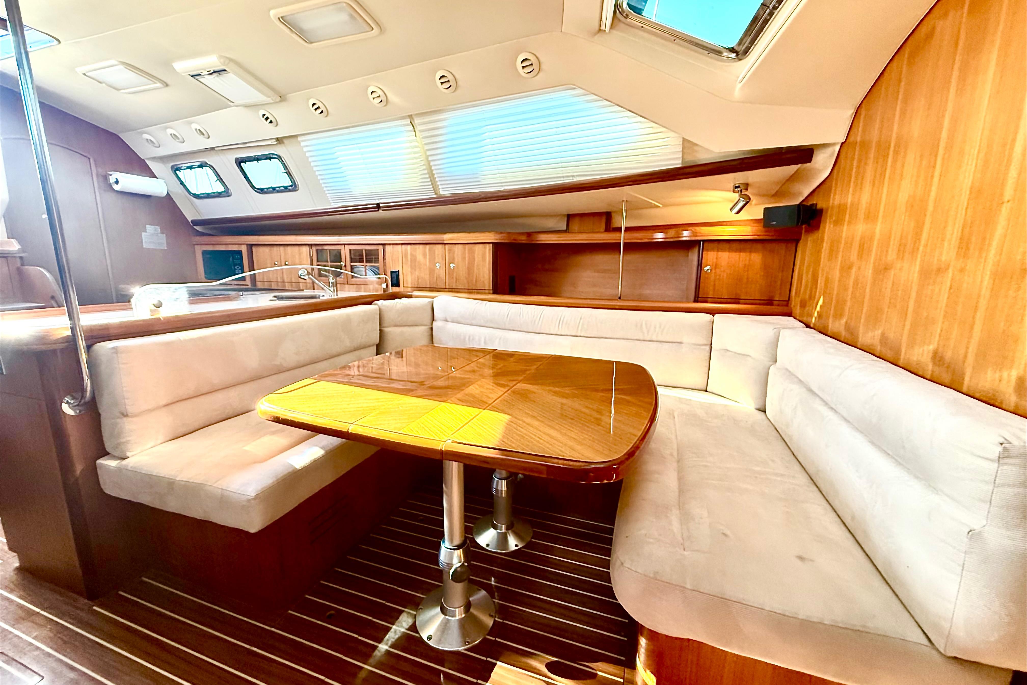 Luxurious interior of 2007 Hunter 41 Deck Salon with plush seating and wooden table.