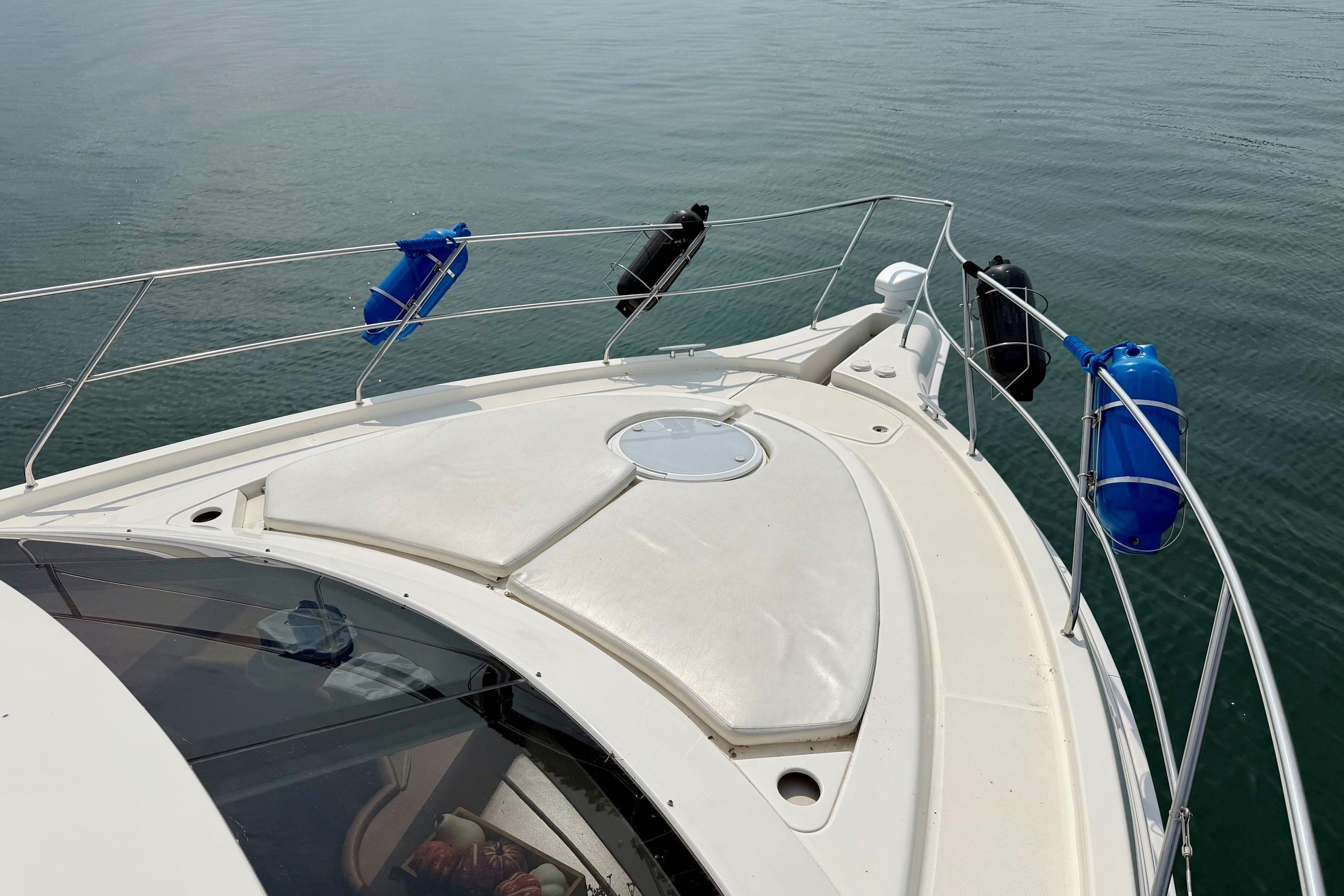 2004 Silverton 39 Motor Yacht bow with fenders on calm water.