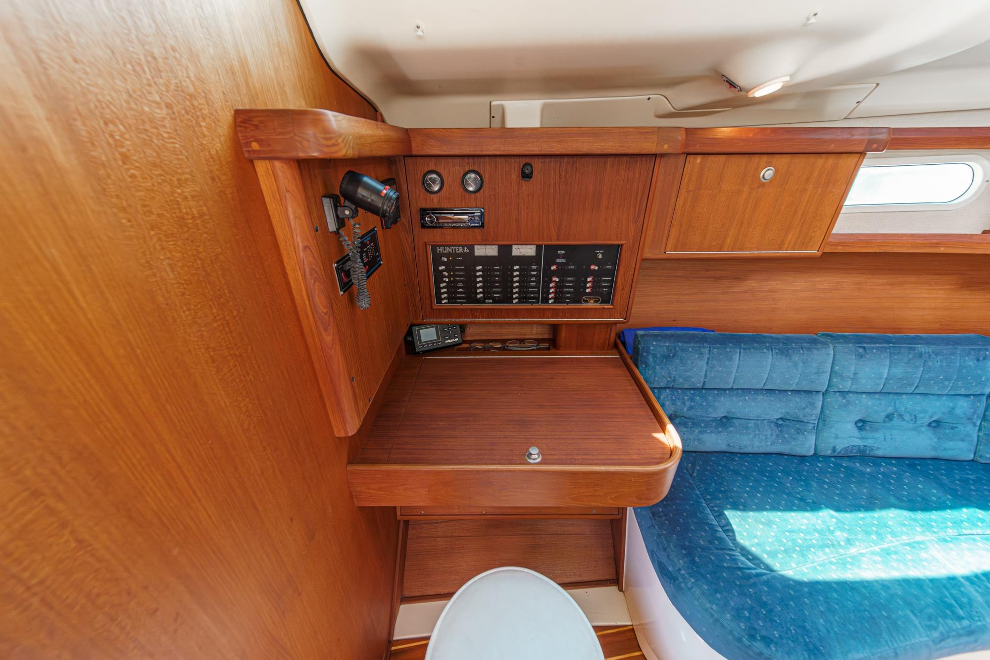 Interior of a 1996 Hunter 376 sailboat with navigation panel and blue seating.