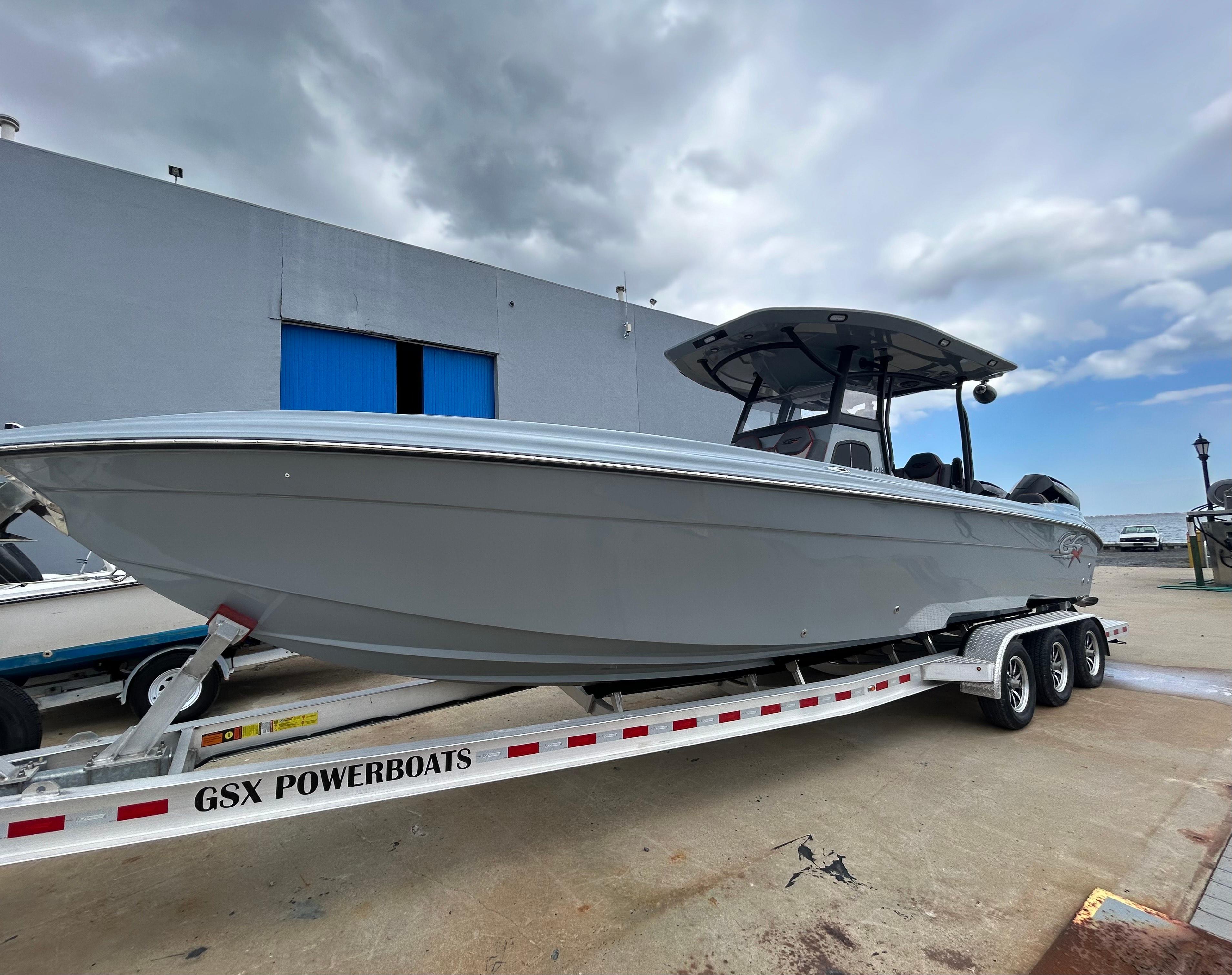 2024 Glasstream 32 GSX powerboat on trailer, parked outdoors under cloudy sky.