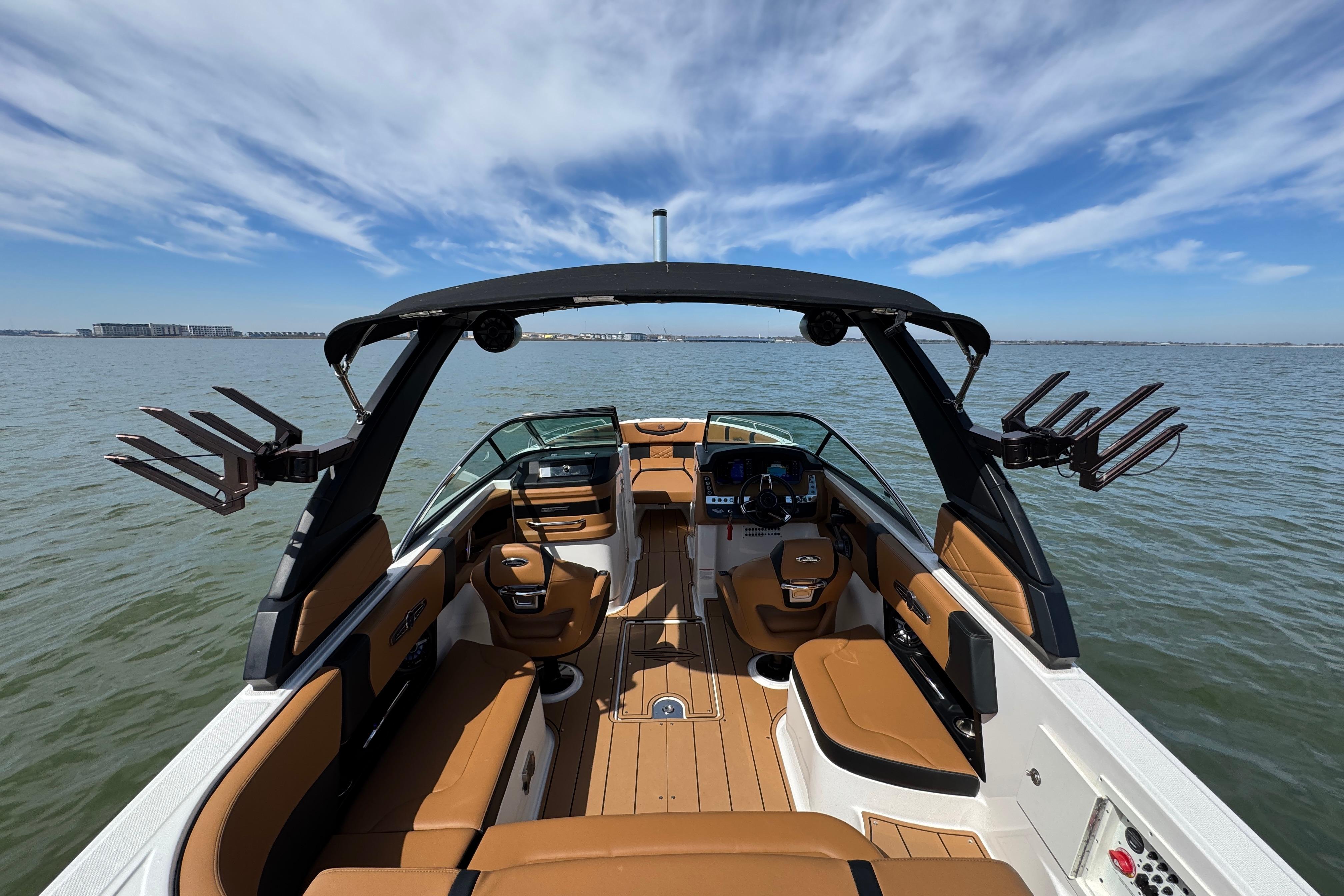 2023 Chaparral 26 Surf boat interior with tan seating on open water.