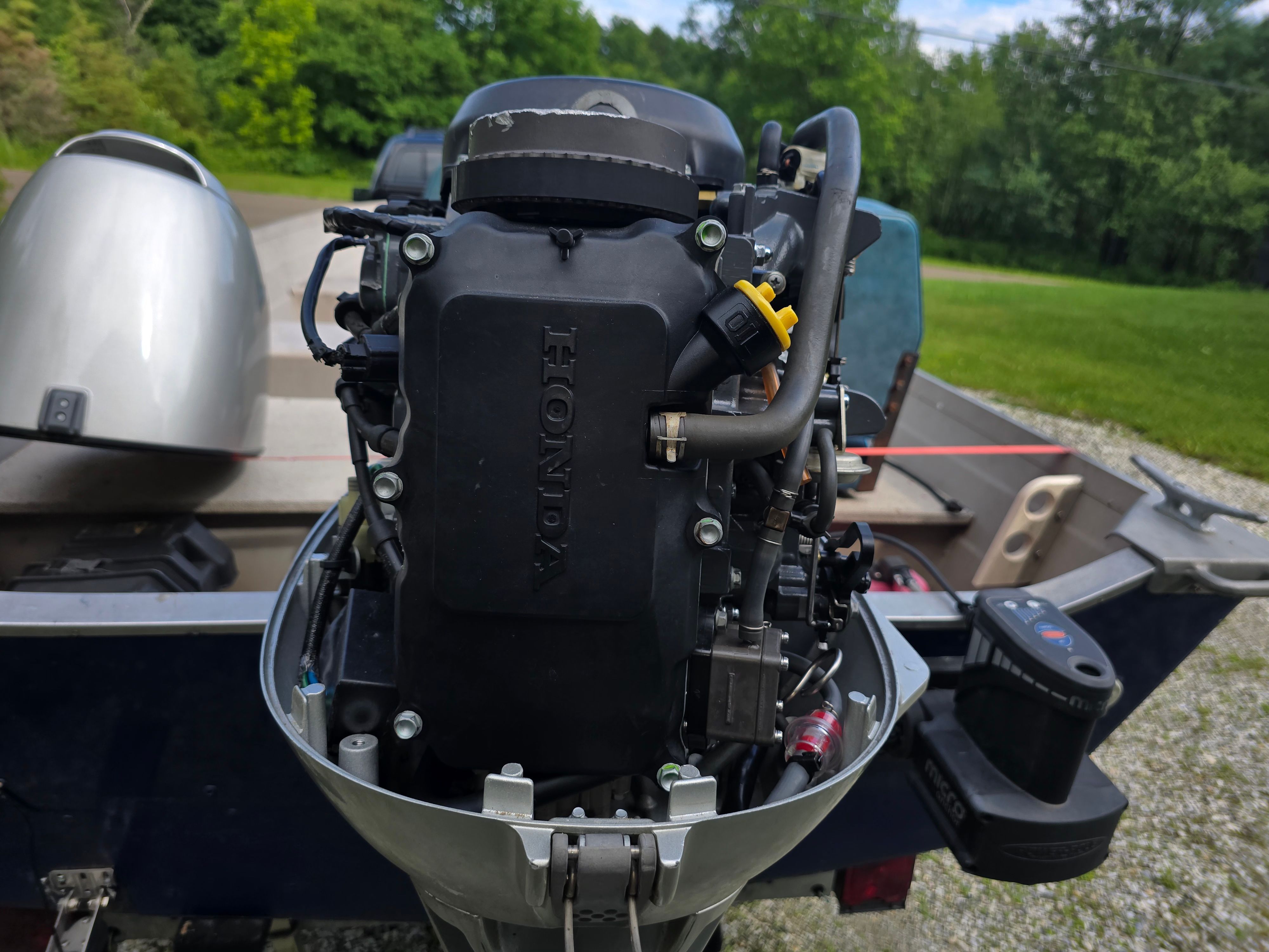 A Honda outboard motor is attached to a boat on a trailer.