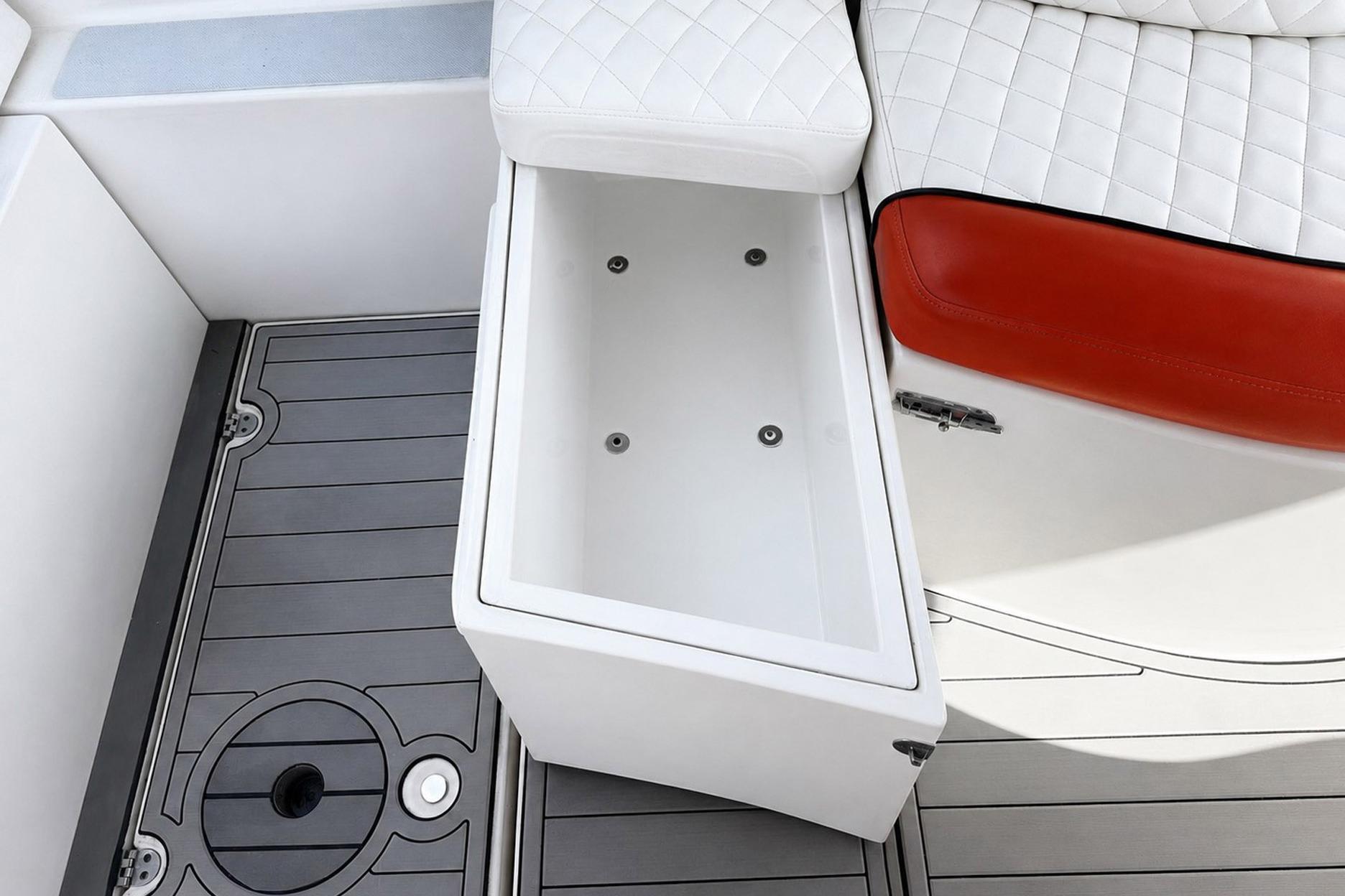2012 Rinker 310 Express Cruiser LE interior with open storage compartment and cushioned seating.