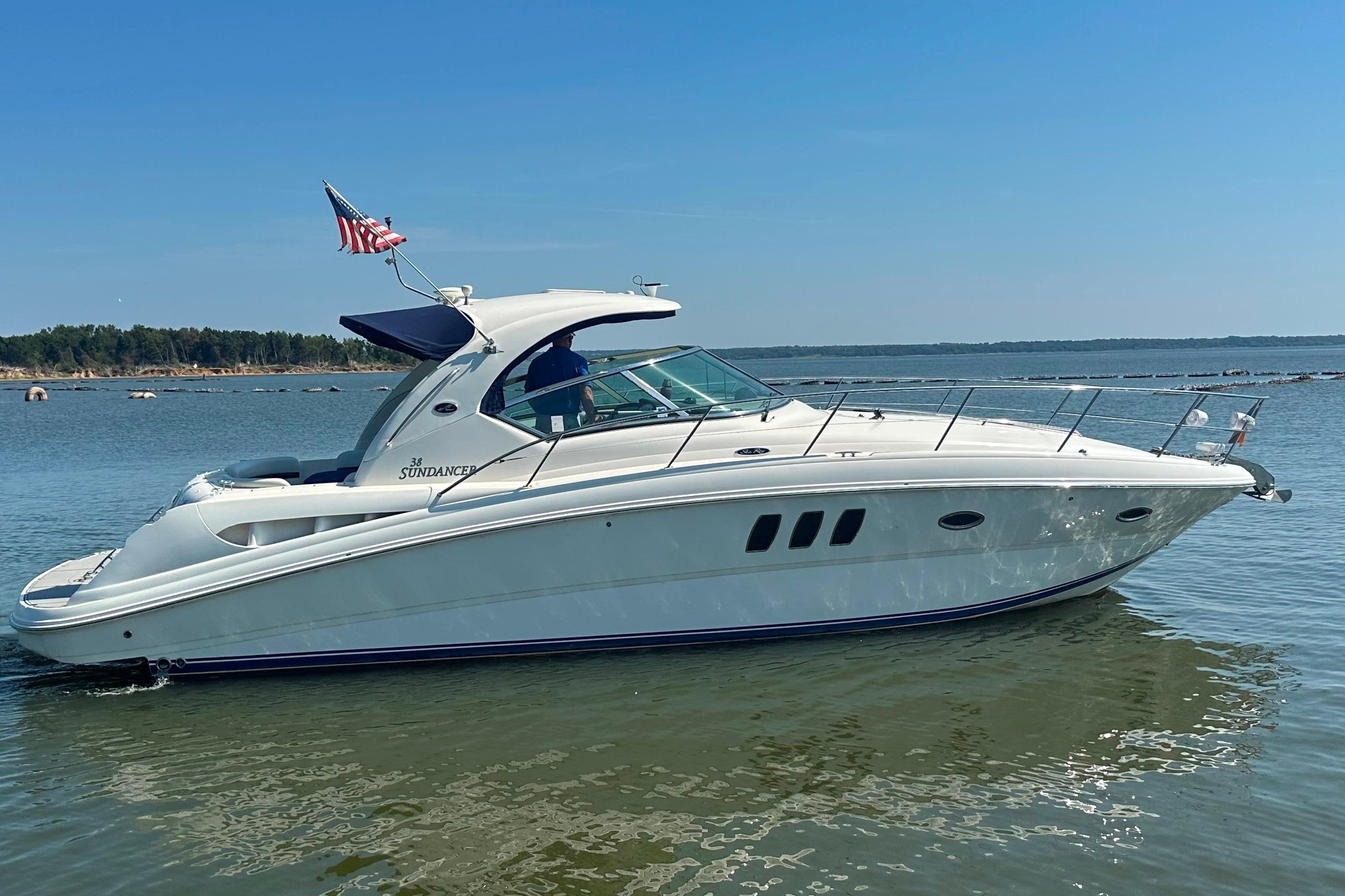 2007 Sea Ray 38 Sundancer yacht on calm water with American flag.