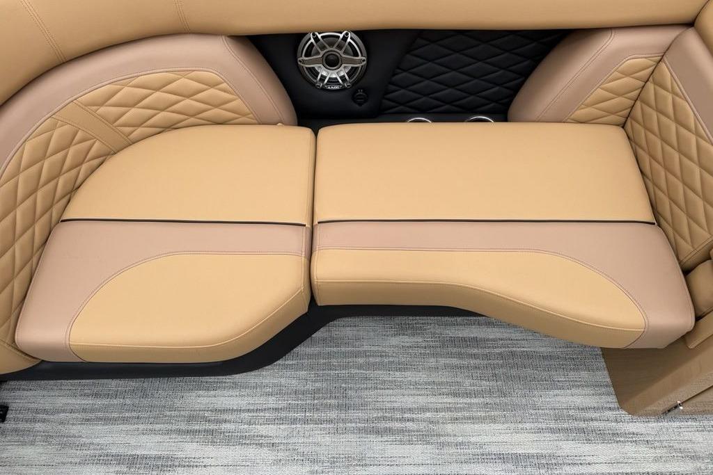 Luxurious tan seating on 2026 Godfrey Monaco 235 SFLC iMPACT boat, featuring quilted design and speaker.