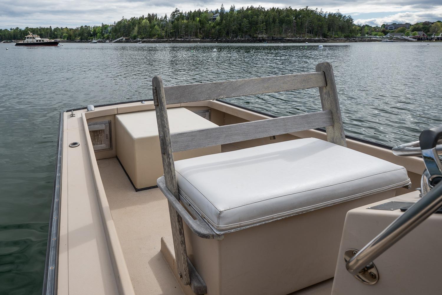 1989 Ellis 24 Open boat with white seating, on calm water with scenic background.